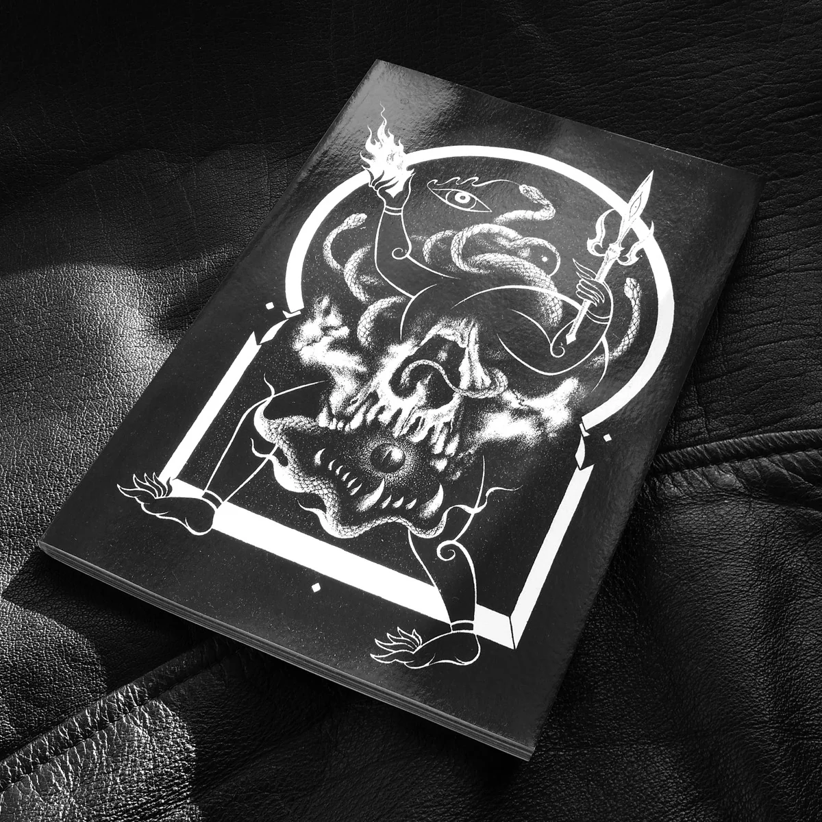 A black cover of a zine with a white abstract illustration