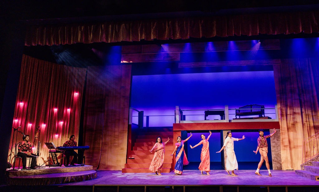 A stage production with four people on the stage and two musicians to the side