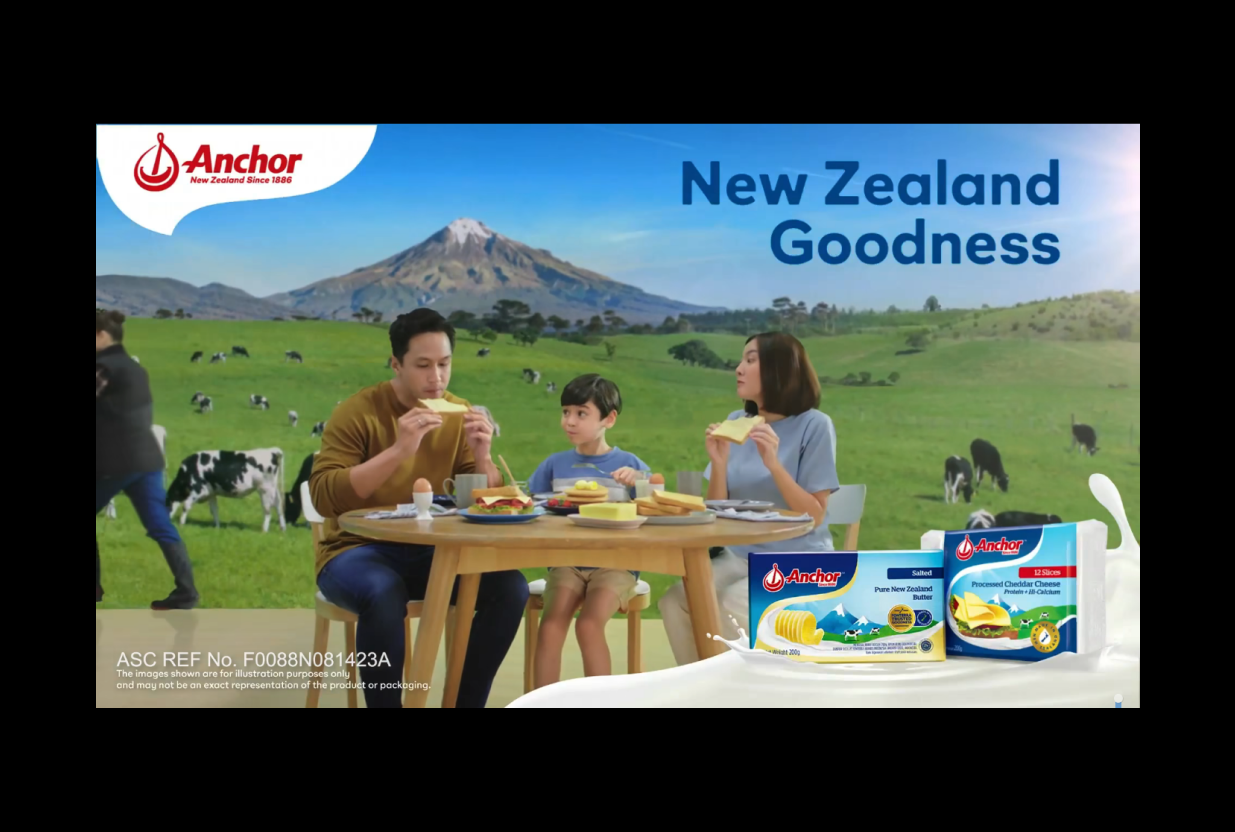 Colourful advertisement of a Filipino family enjoying dairy products in front of a New Zealand backdrop.