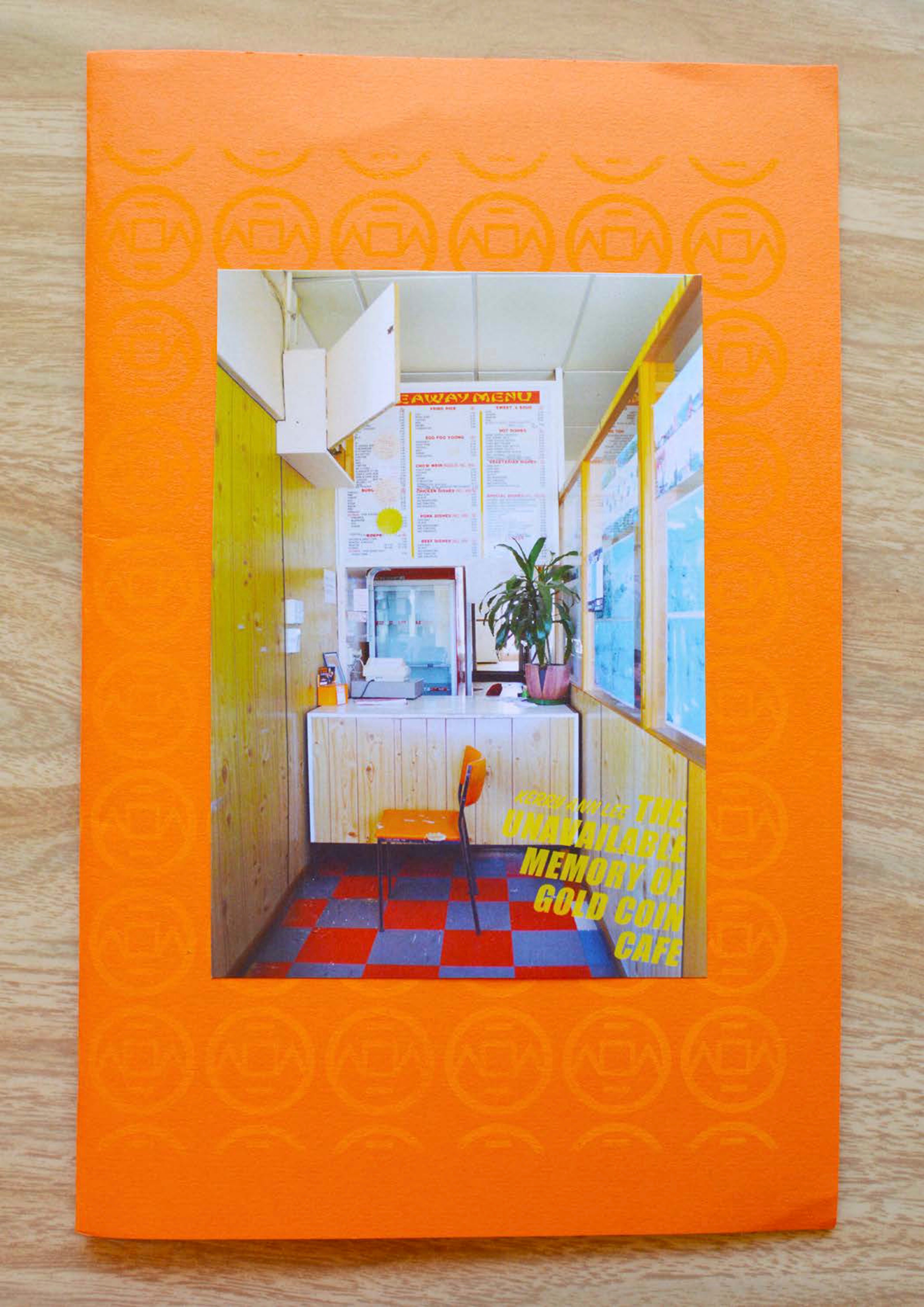 Photograph of the counter of a takeaway shop stuck onto a bright orange zine cover