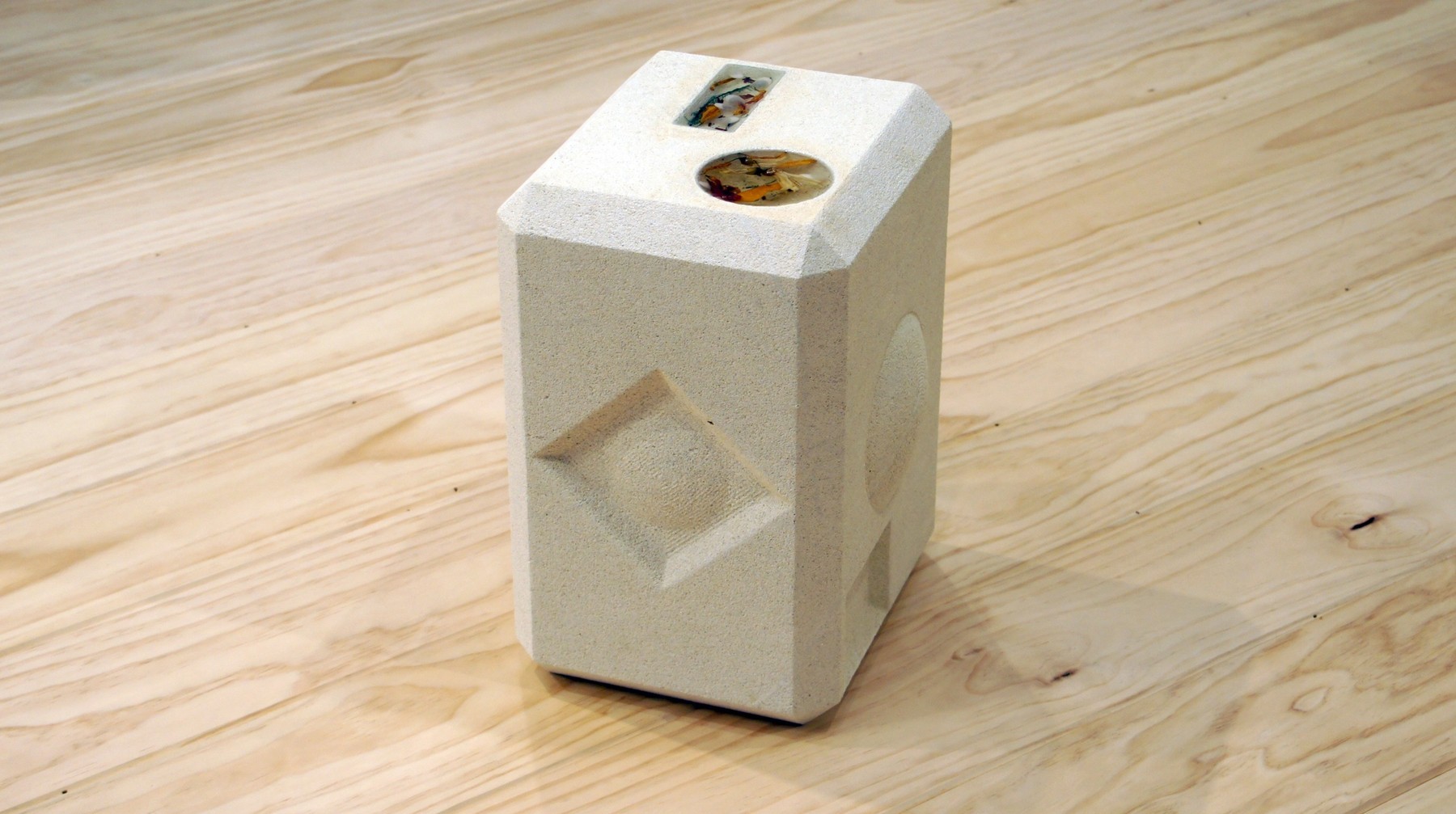 A white cast small speaker with objects embedded