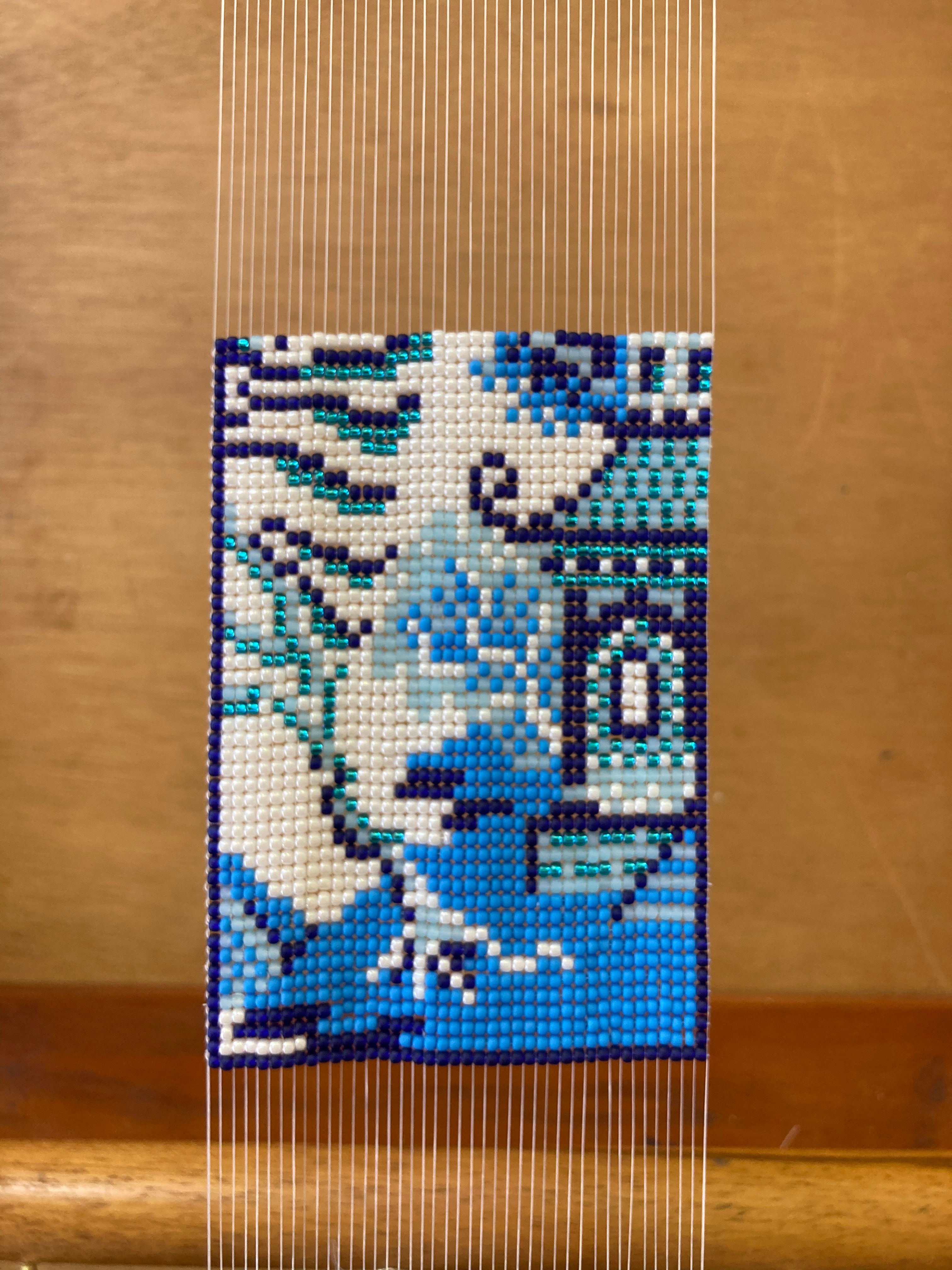 A beadwork in progress, showing a traditional Chinese blue and white pagoda and willow scene.