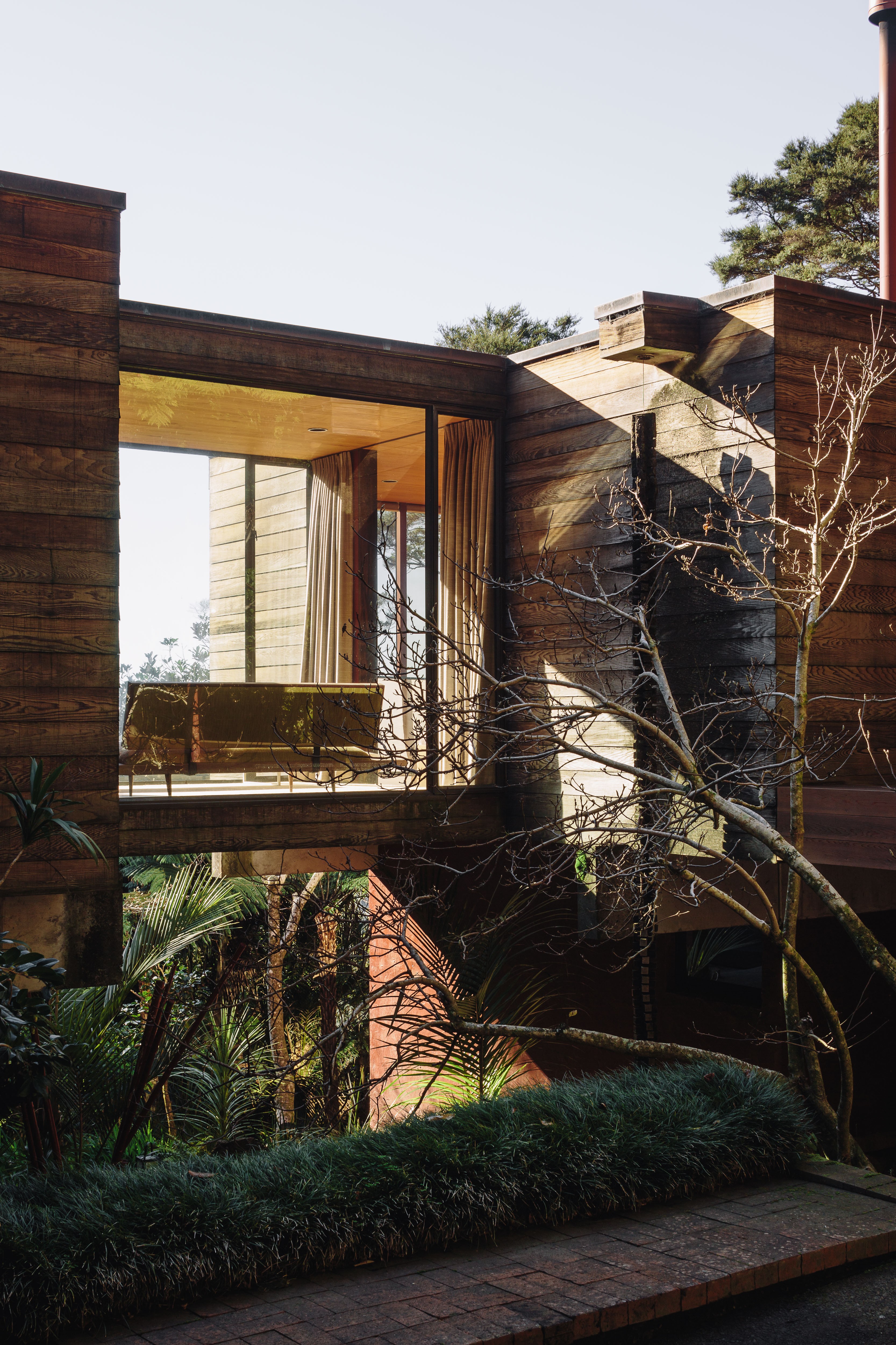 A house amongst trees with floor-to-ceiling glass windows