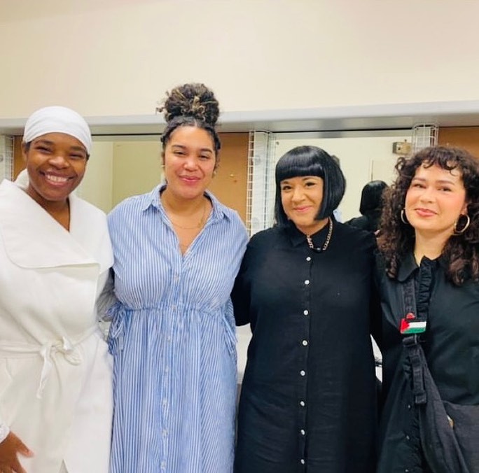 A photo of four women standing in a row