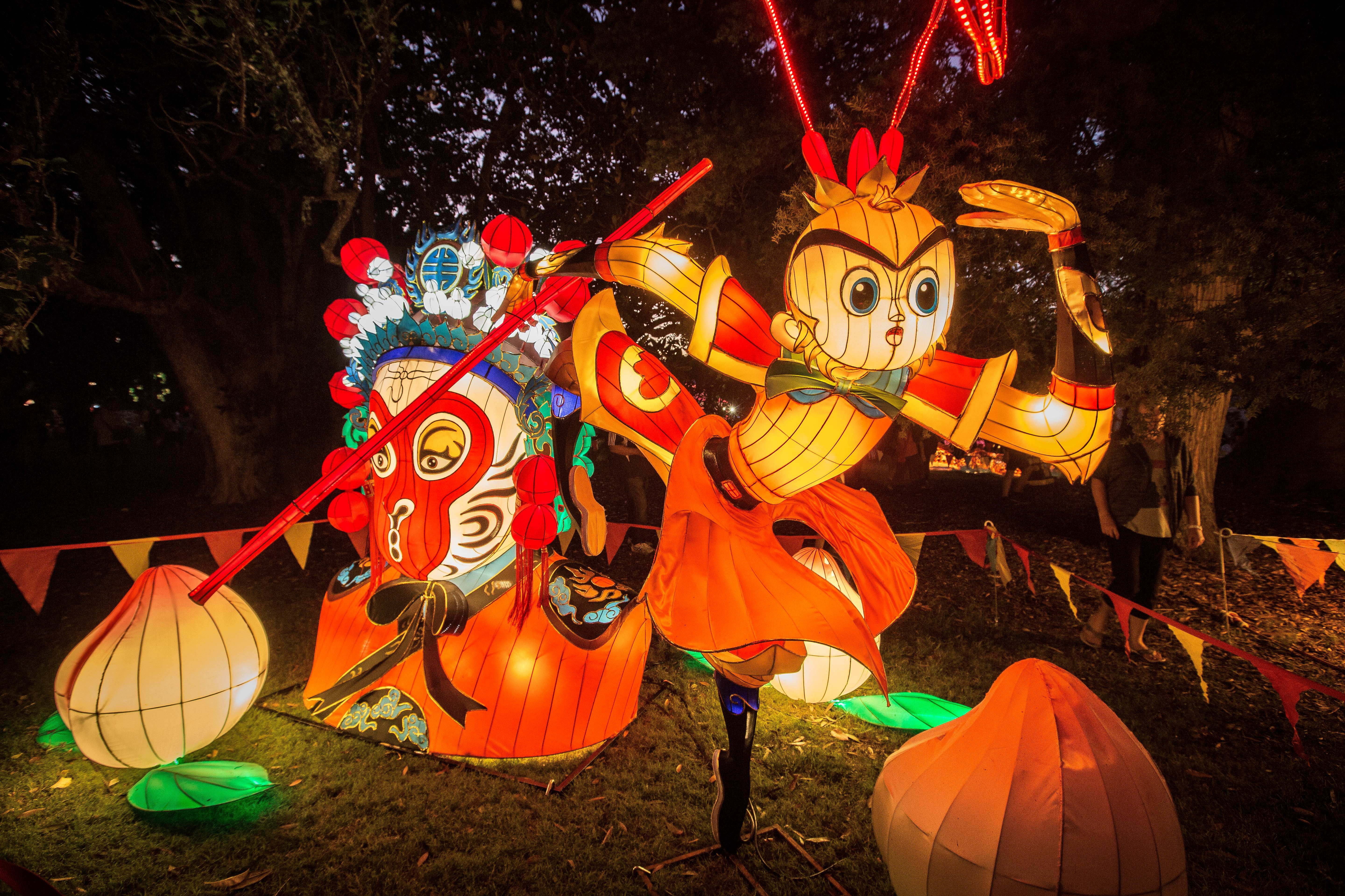 Multi-coloured sculptures with lights surrounded by flags