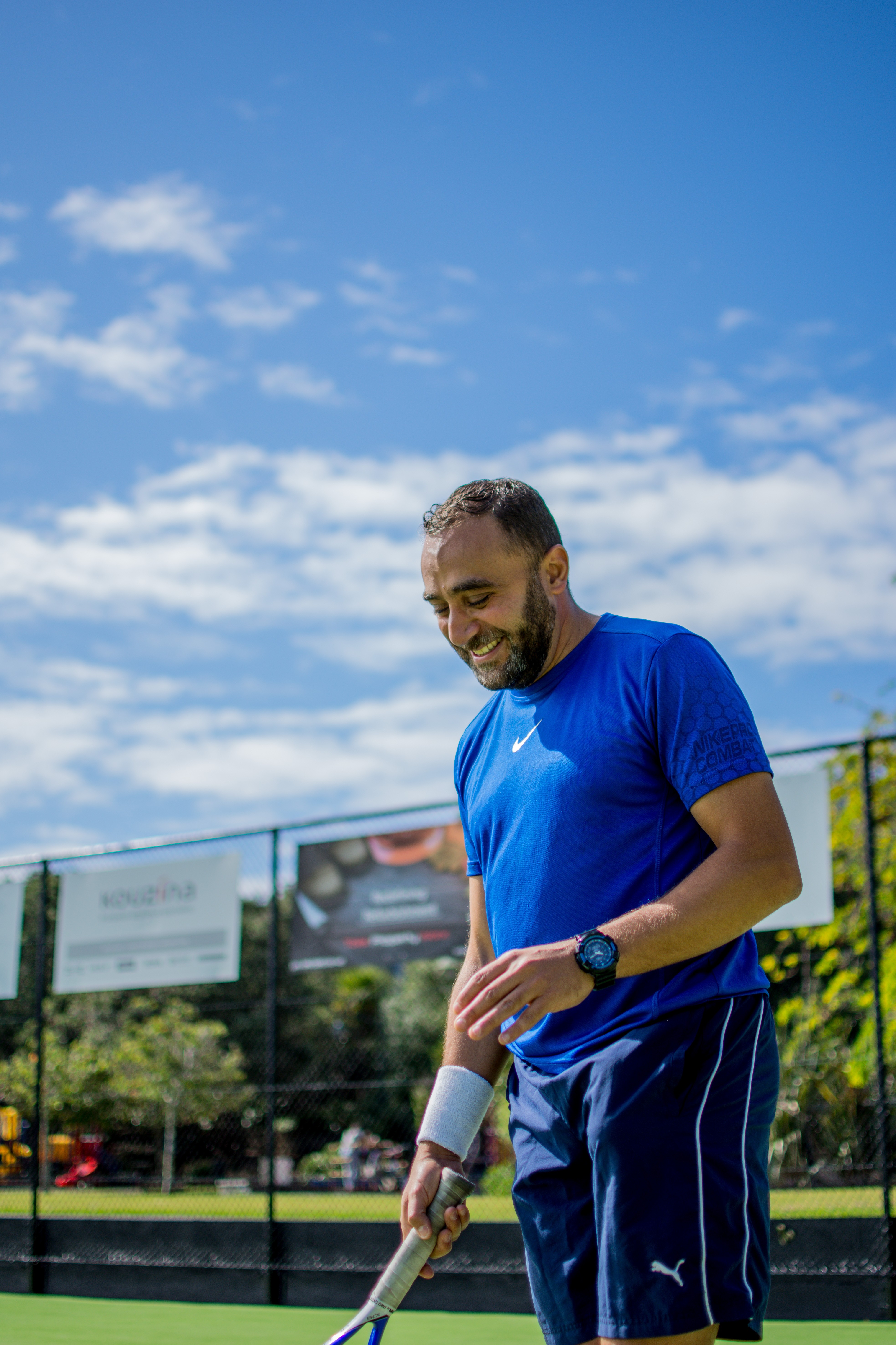 In a scene from 'This Is Us', a man wearing a blue t-shirt holds a tennis racket on a tennis court.