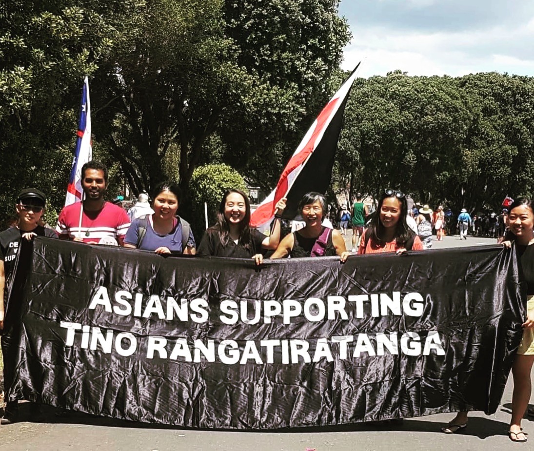 A group of people holding an 'Asians Supporting Tino Rangatiratanga' banner