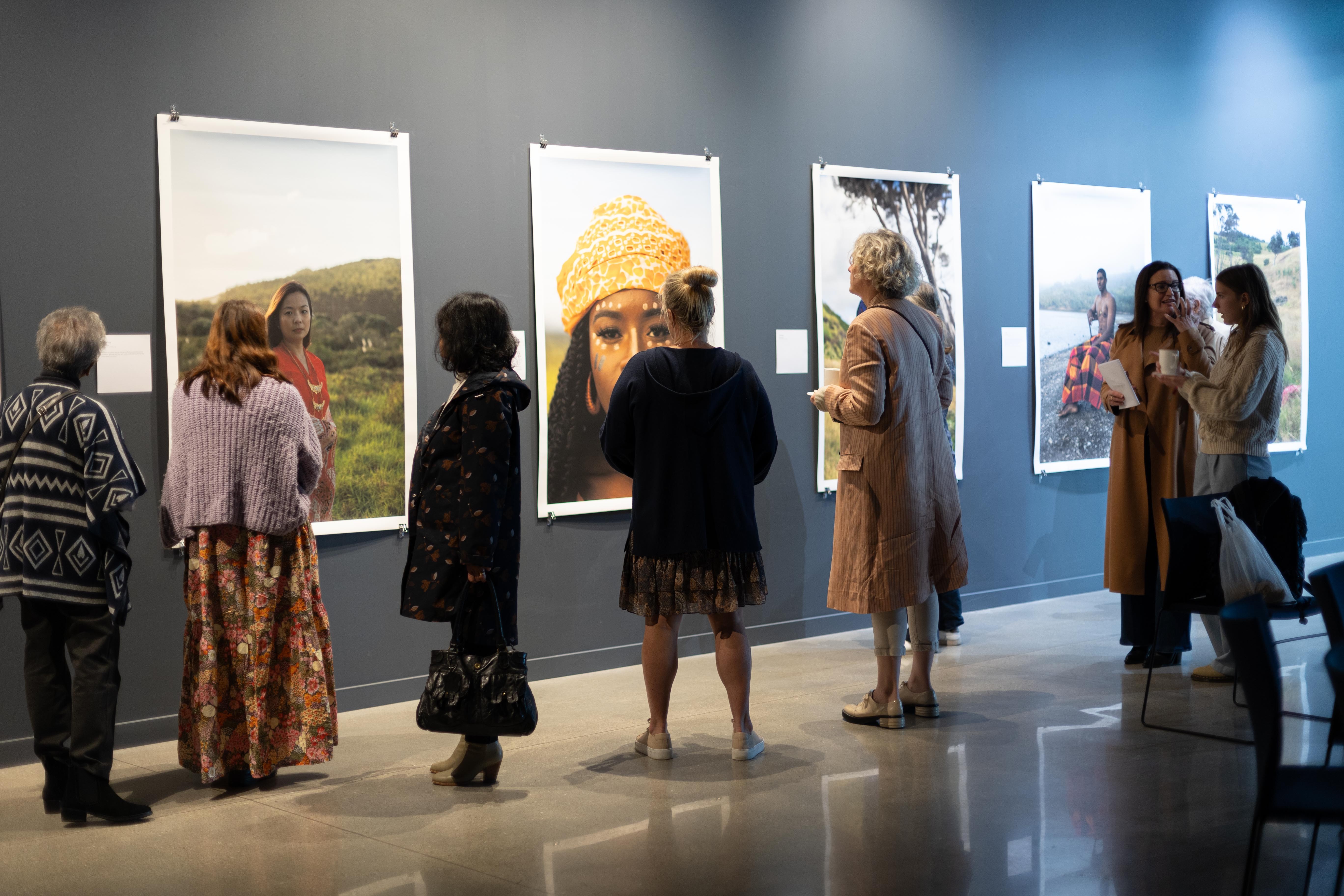 People viewing large photographs in a gallery