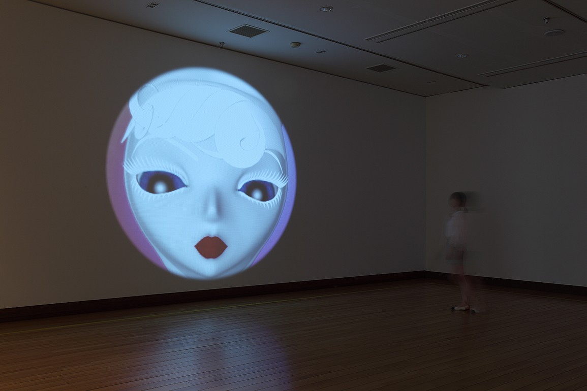 Circular projection onto a gallery wall of an animated woman.