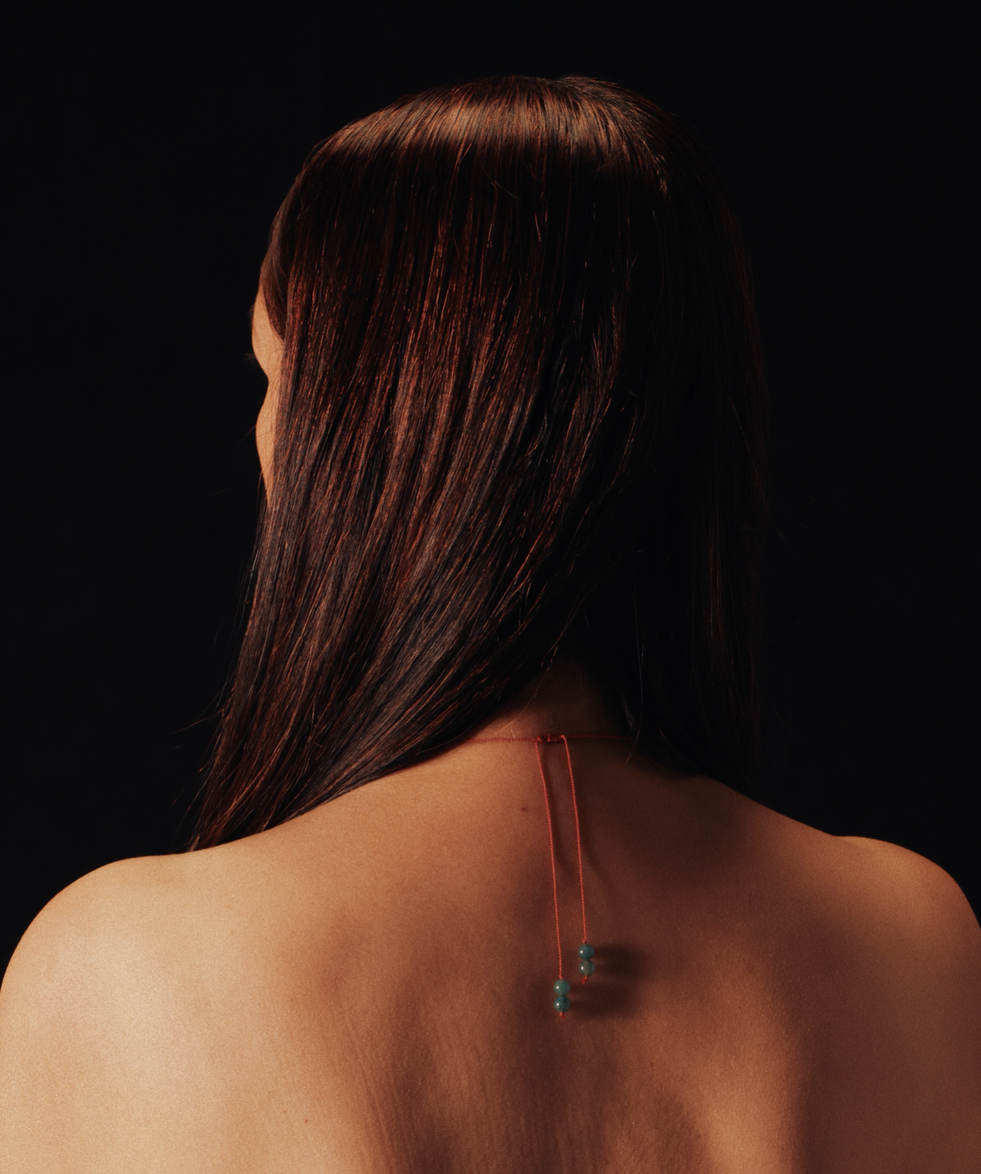 half body shot a model facing back, showing jewellery on their bare back