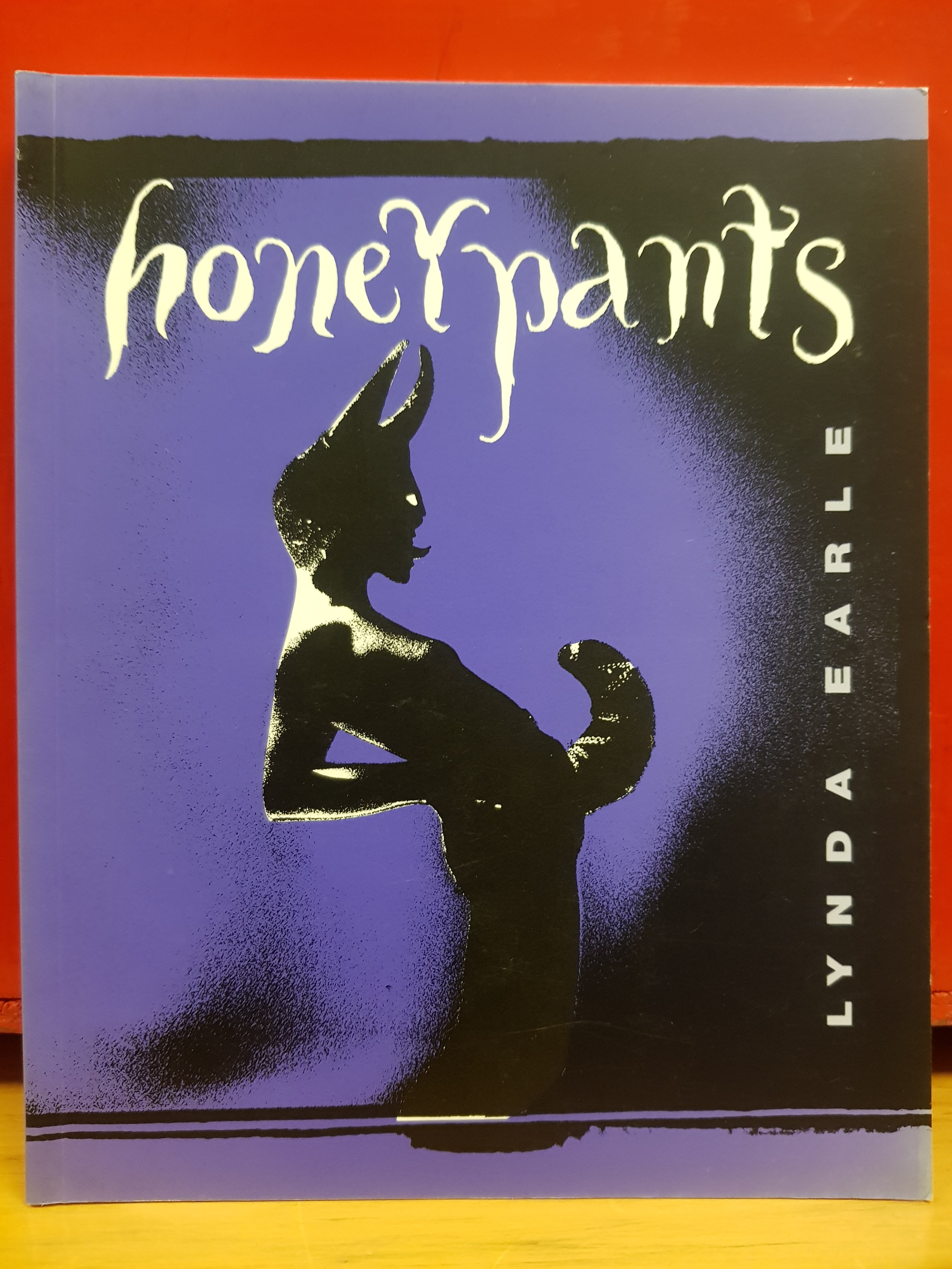 A photo of a book cover. The title is styled in an uneven hand-drawn typeface against a purple and black background. Illustrated in silhouette is a horned figure wearing a codpiece.