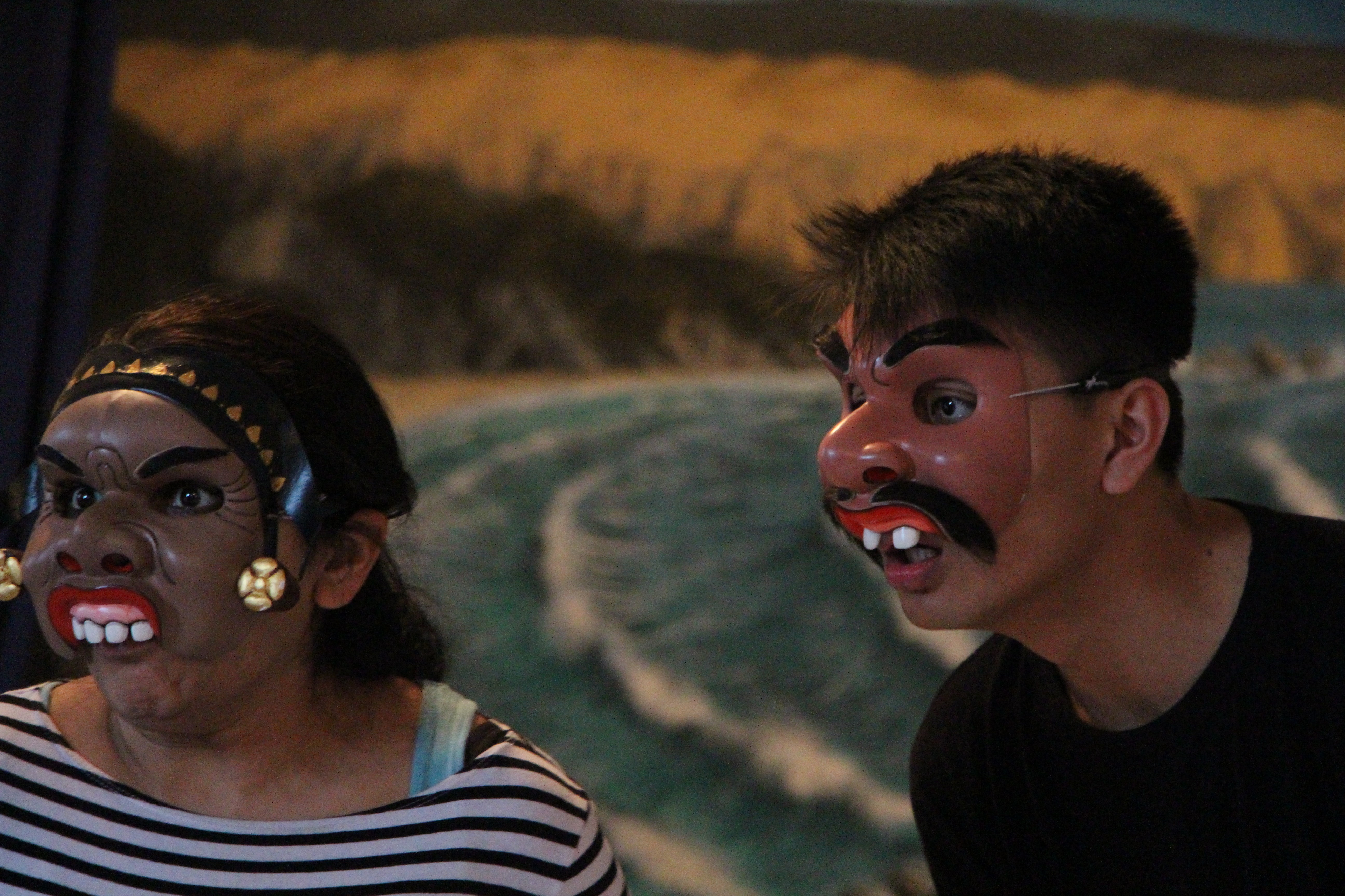 Two people wearing masks with brown skin and protruded teeth