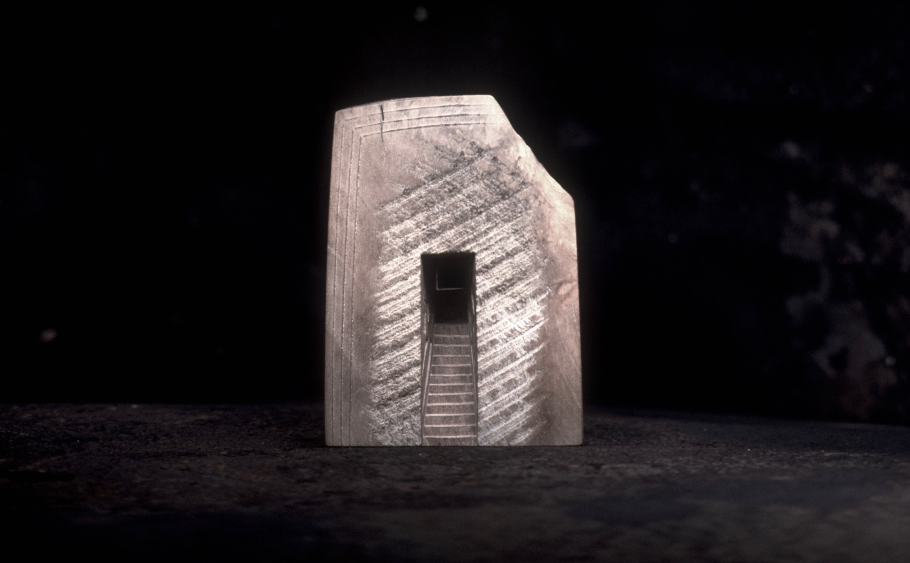 Small plaster sculpture made out of milk carton with a set of stairs carved into the centre