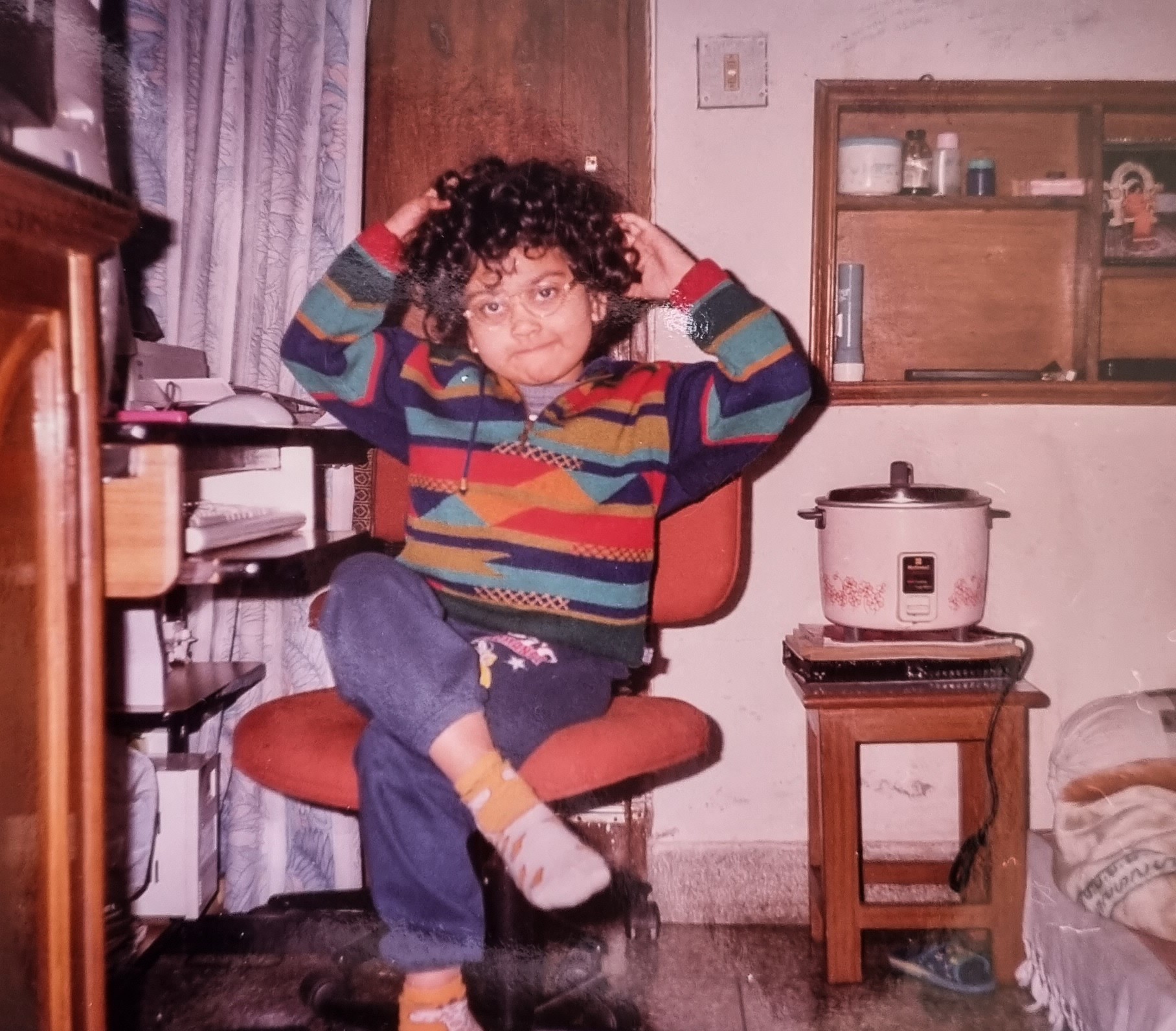 Ankita as a child with glasses and curly hair.