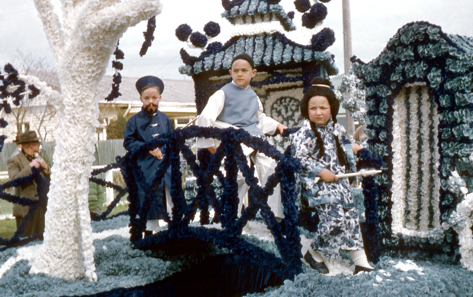 Children in Chinese costumes on a decorated parade float.