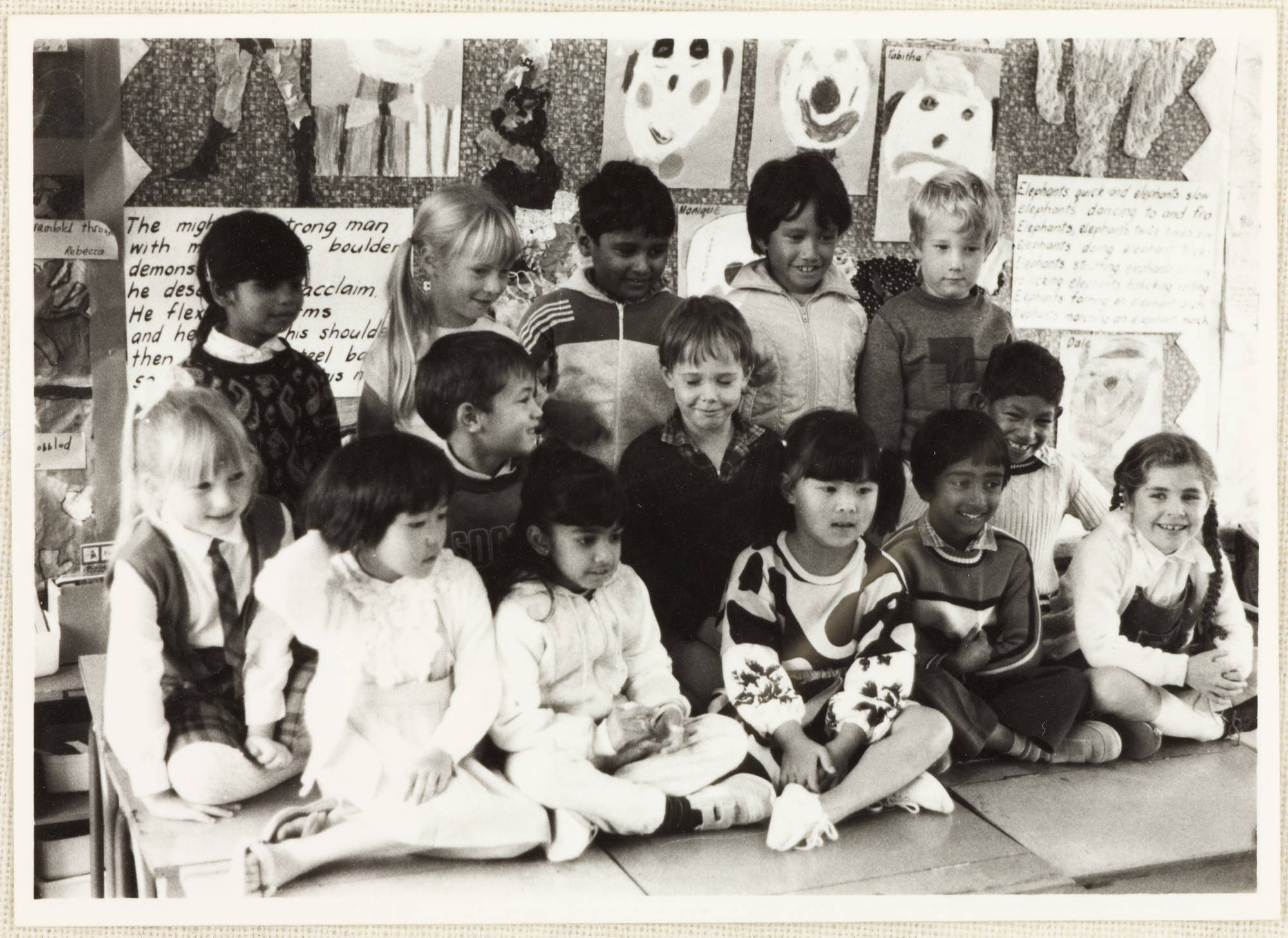 A group of multicultural primary school children in a classroom.