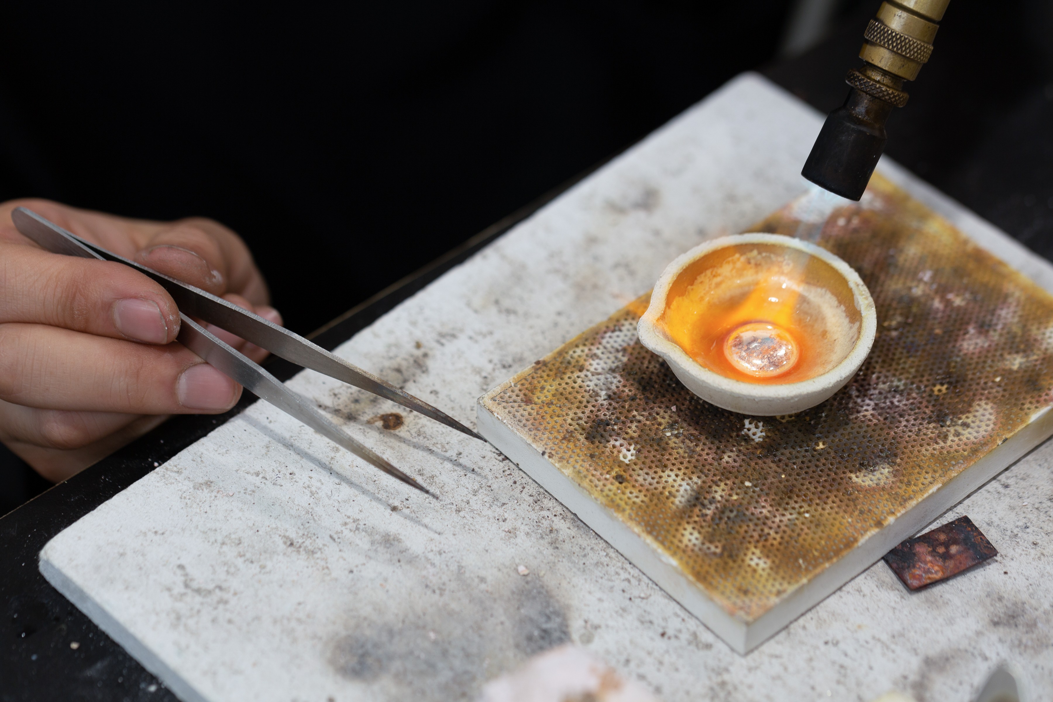 Close-up of one hand firing a ring and the other holding tweezers