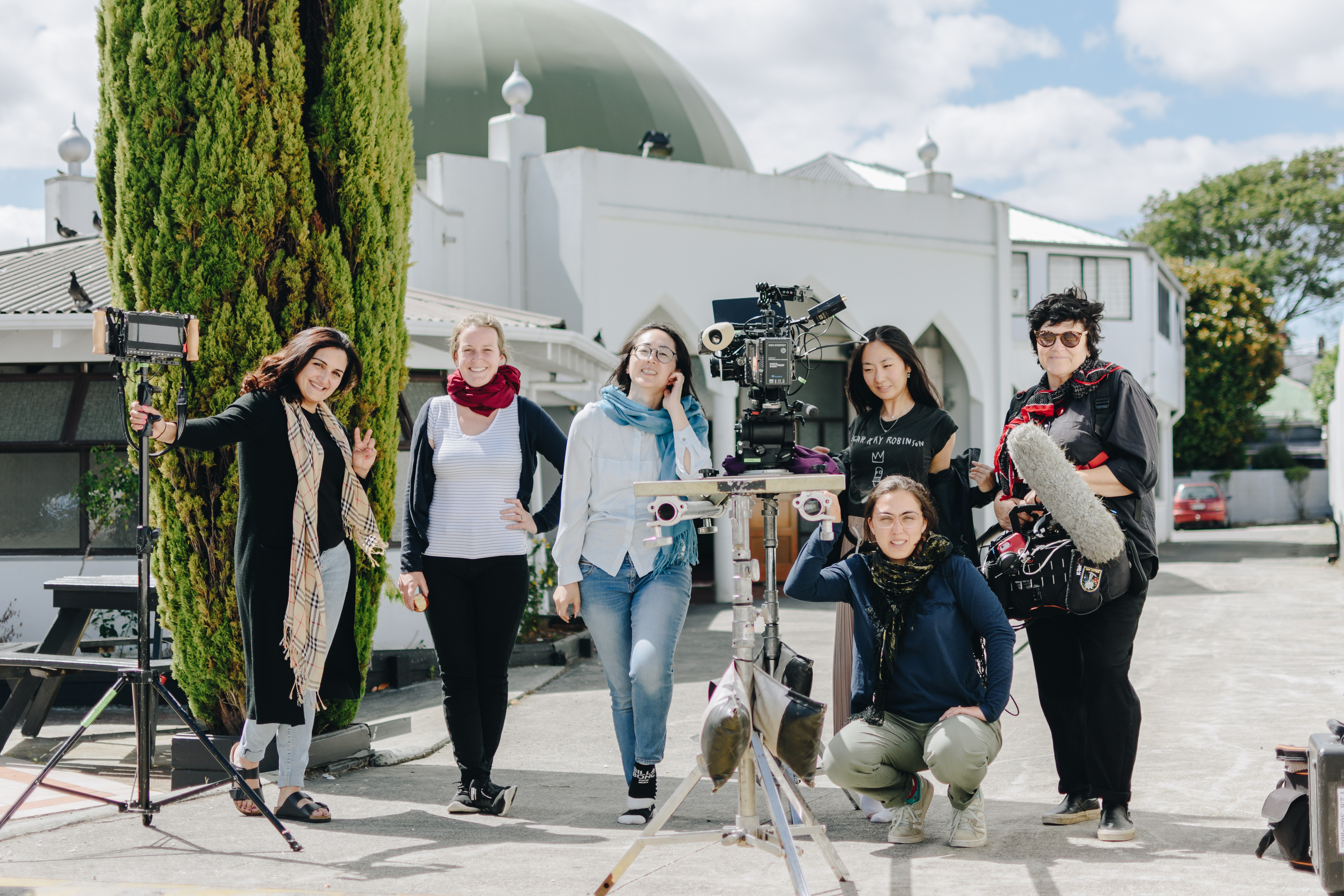 A behind the scenes photo of a documentary crew outside a mosque.