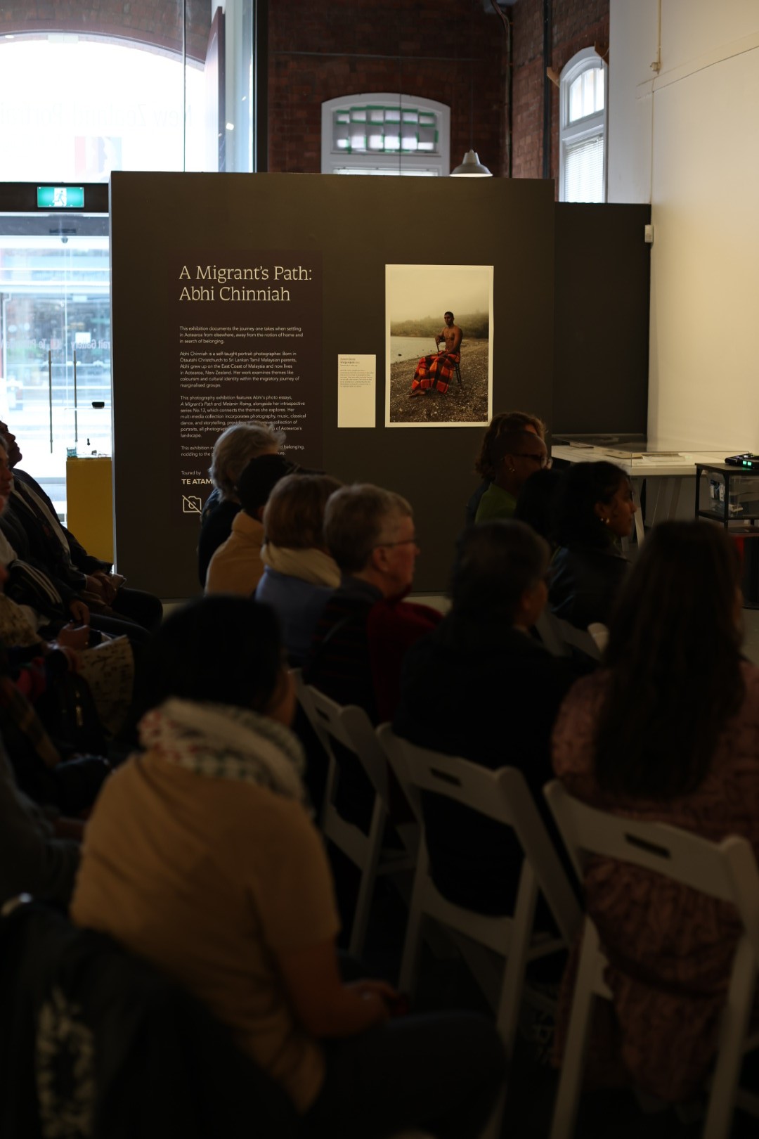 People sitting in chairs in a gallery