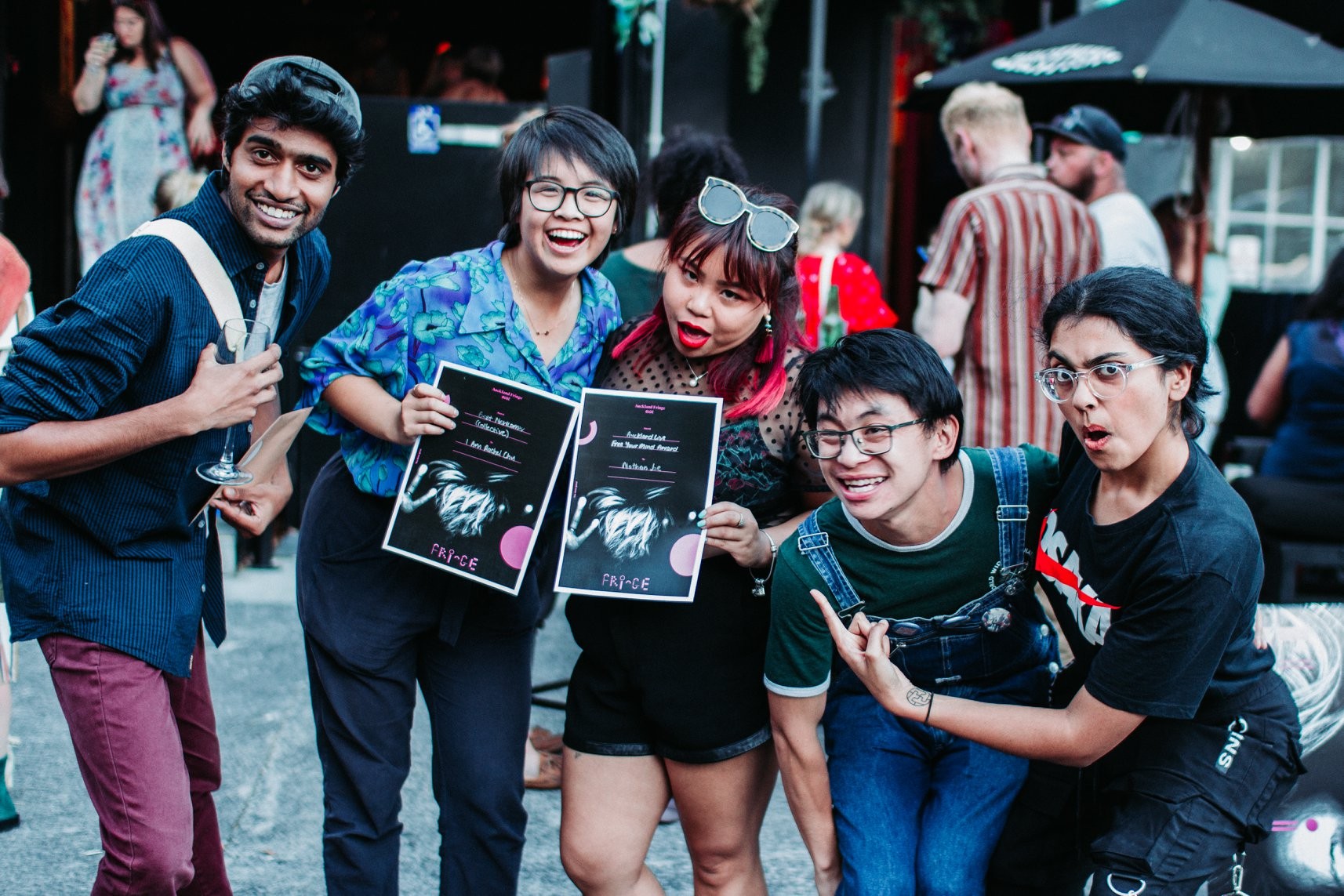 People standing together holding up two printed awards