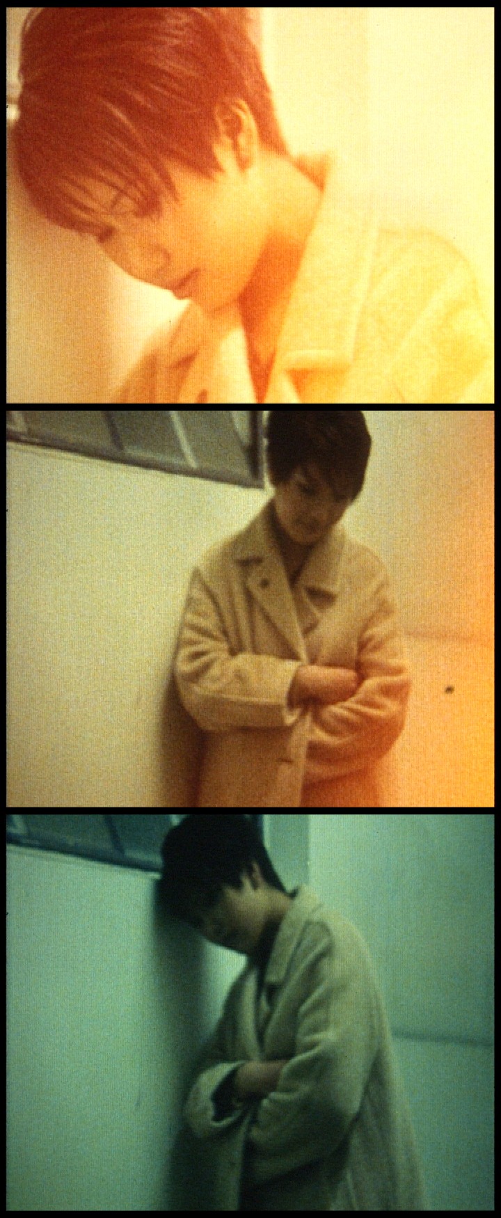 A triptych of film frames, tinted in yellow and green hues, of a woman standing in a beige overcoat.