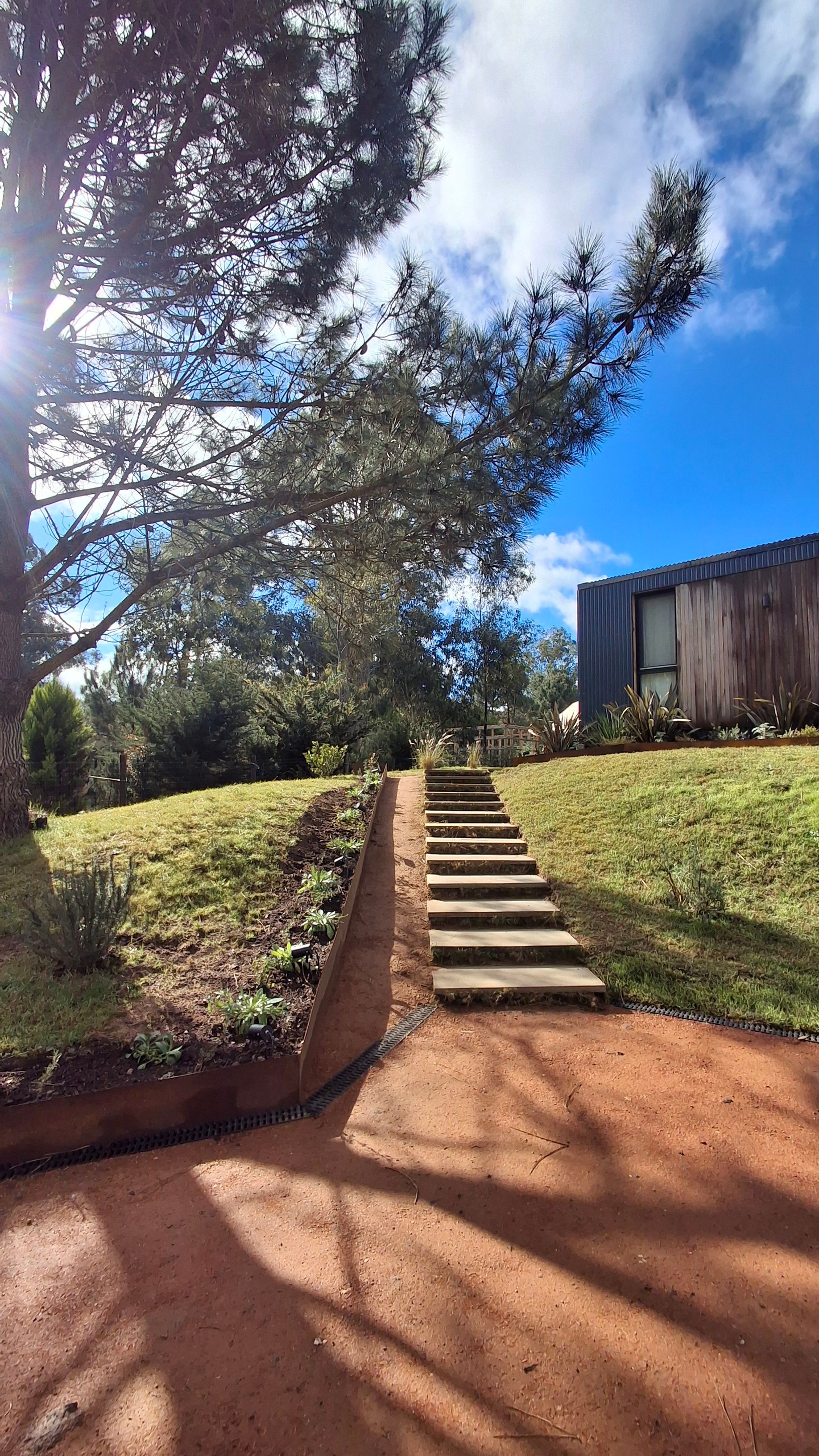 Escalera de acceso a la casa. Canteros acero corten con vegetación nativa. Paisajismo