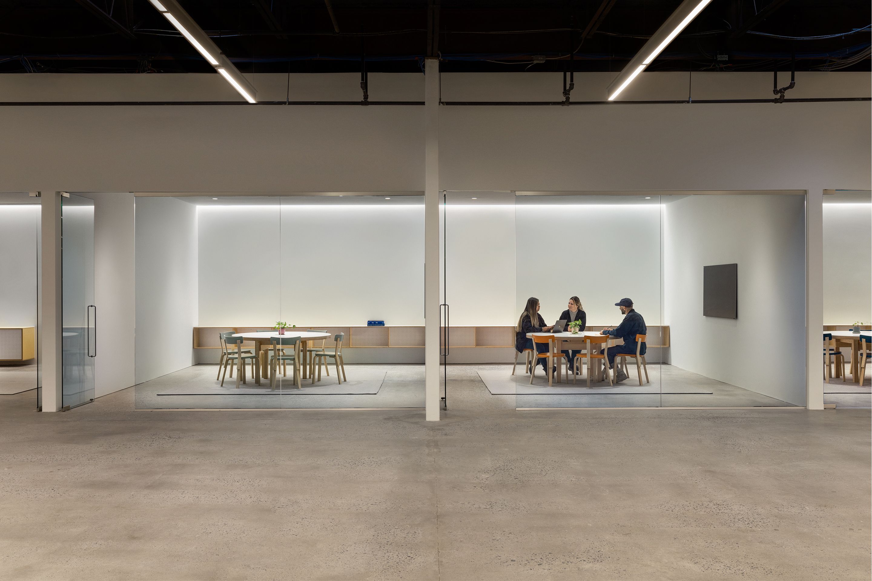 Two RBW conference rooms with people at table inside the right conference room