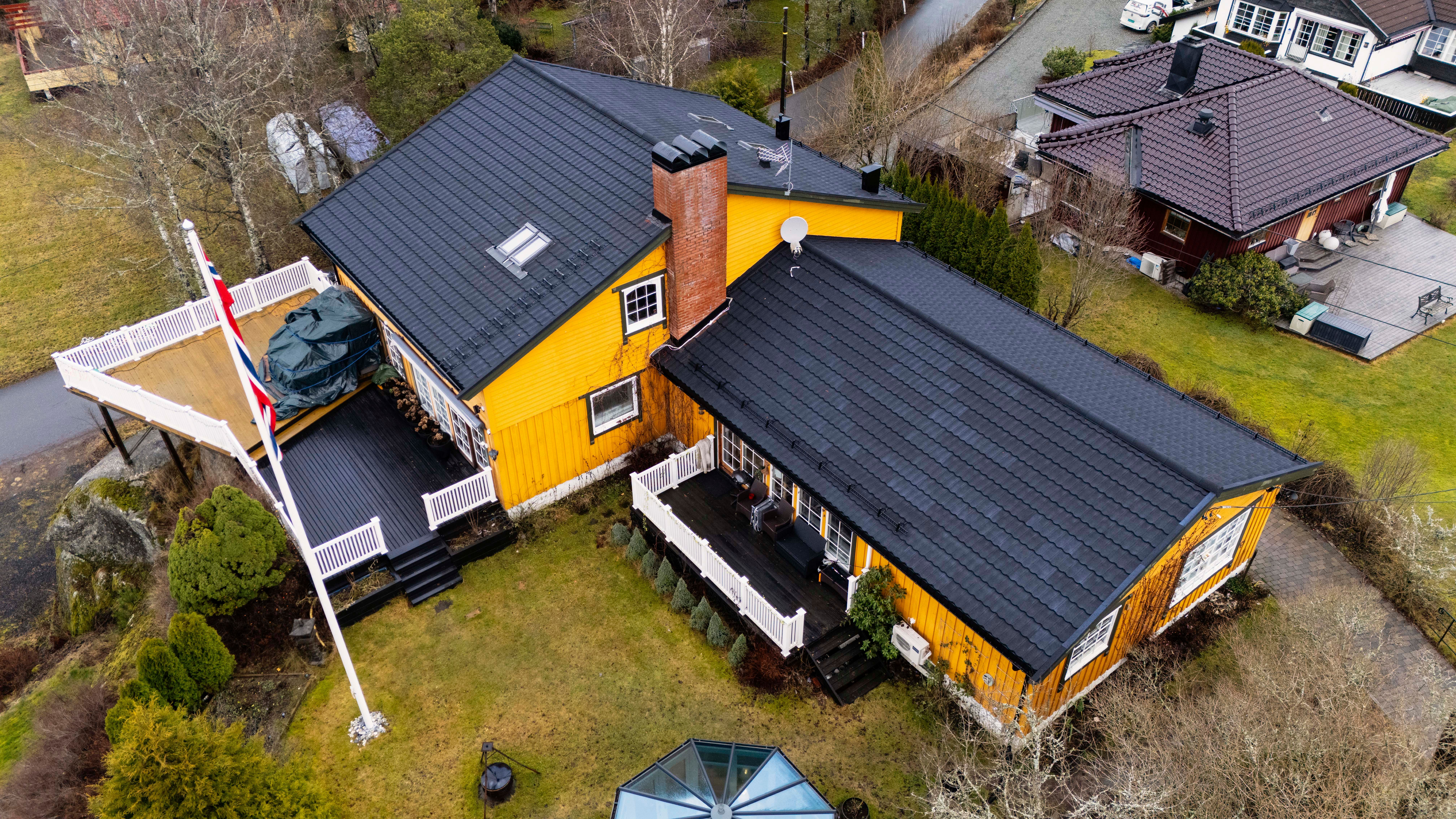 Hus med nytt tak sett ovenfra gult hus med sort taksten