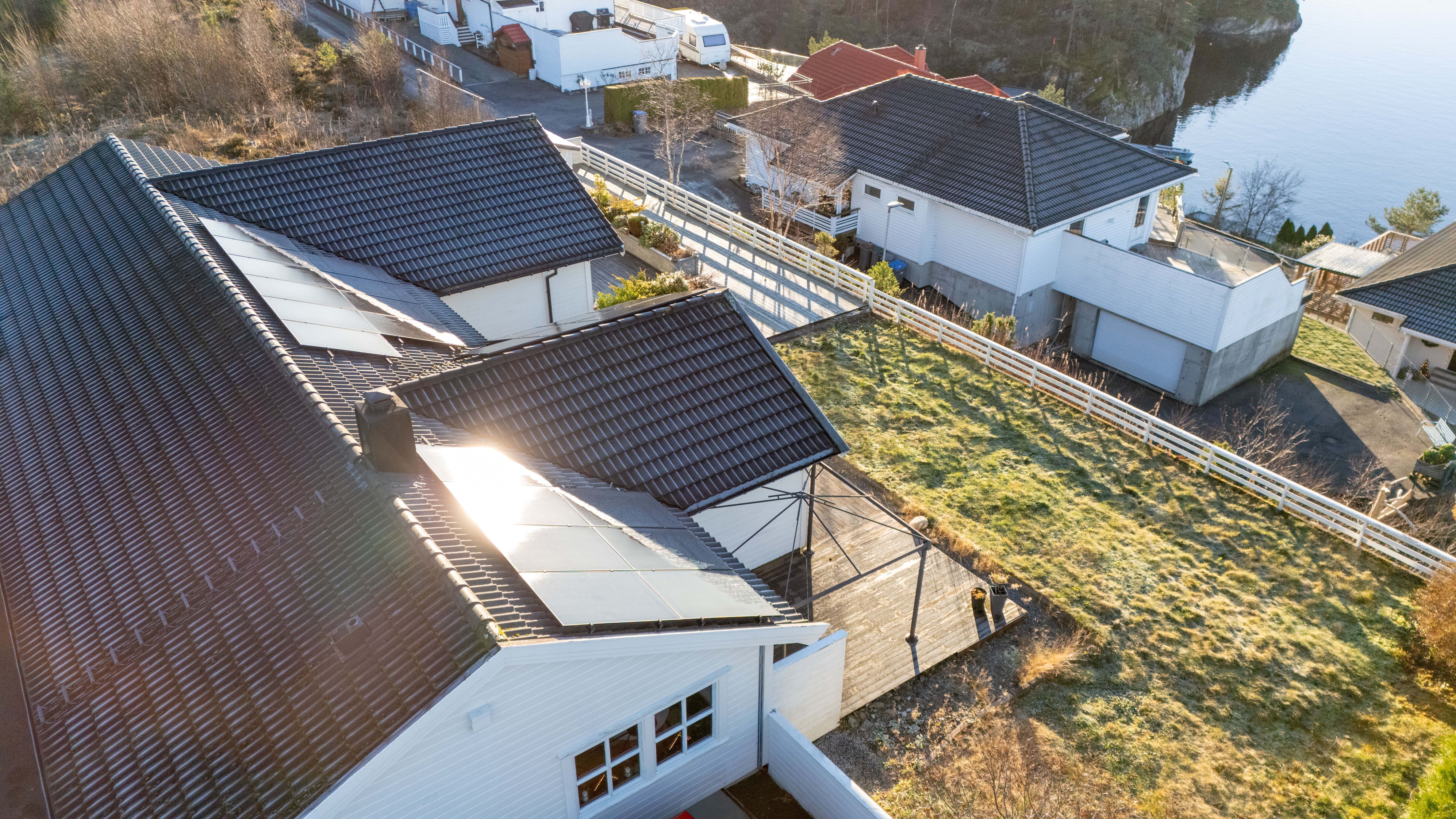 Tak med sort taksten og solceller hvit hus med sjøutsikt