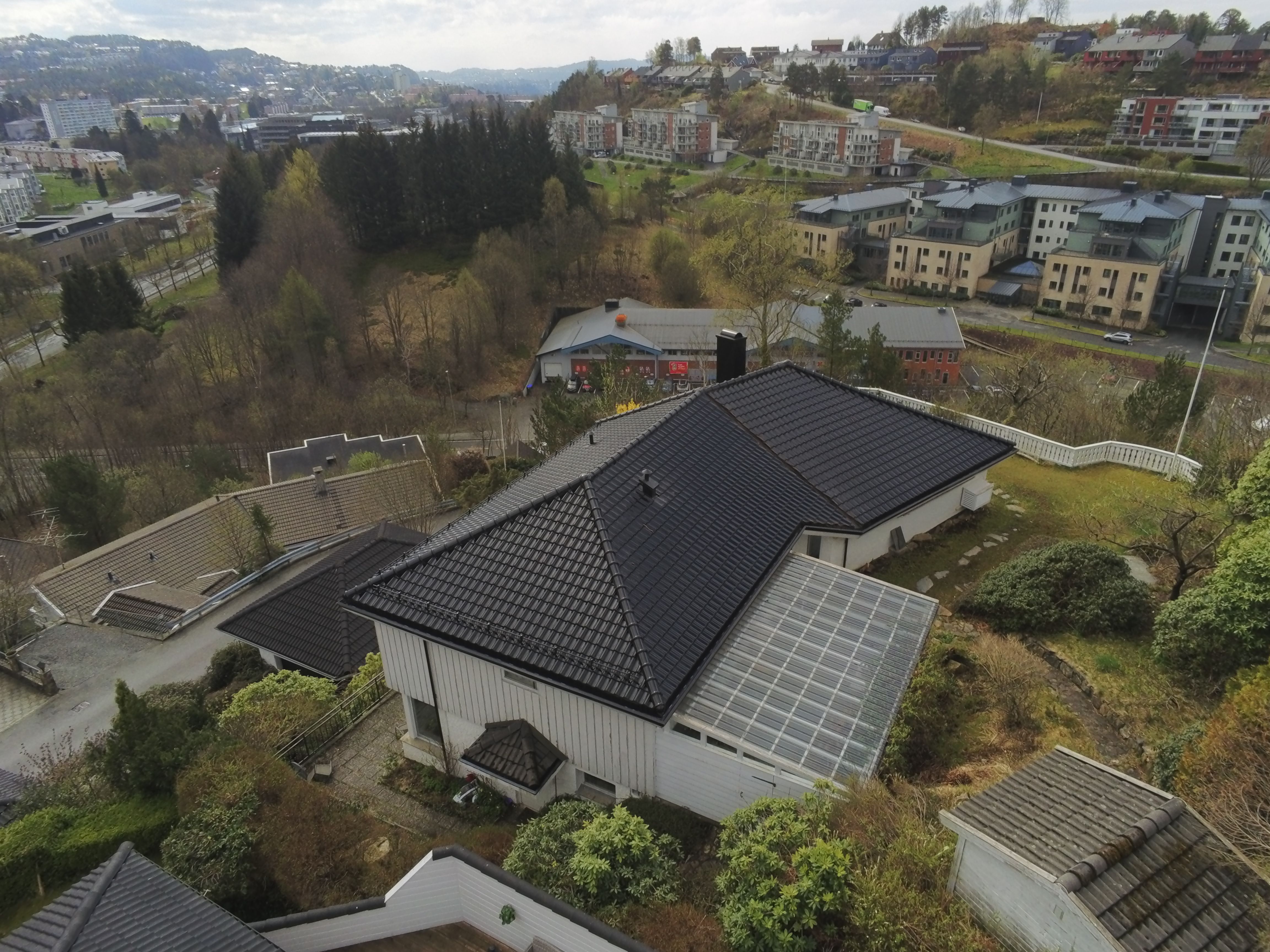 Nytt takbytte sett fra siden av huset hvitt hus med sort taksten