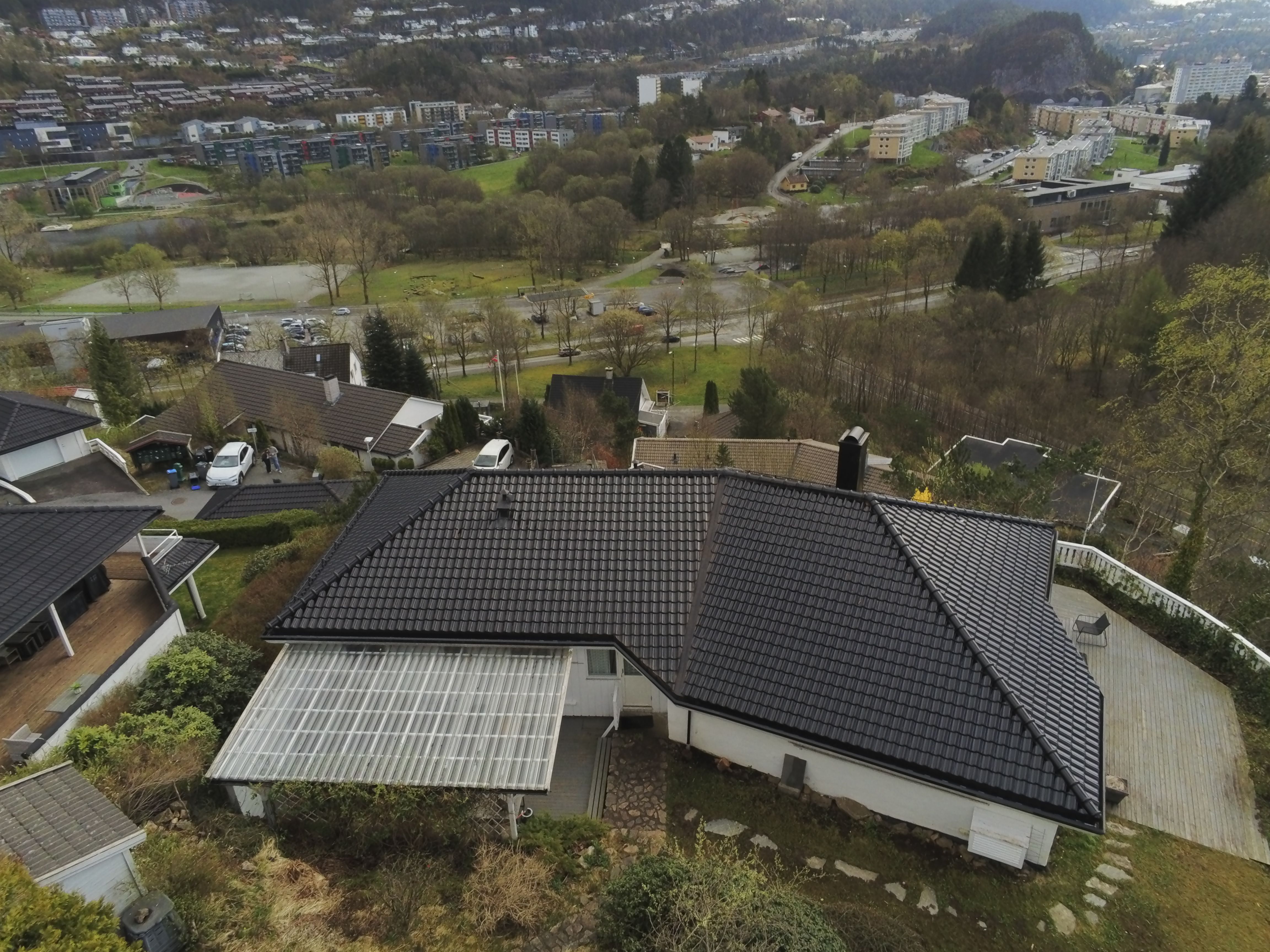 Takbytte sett fra baksiden av huset hvit enebolig med sort taksten 