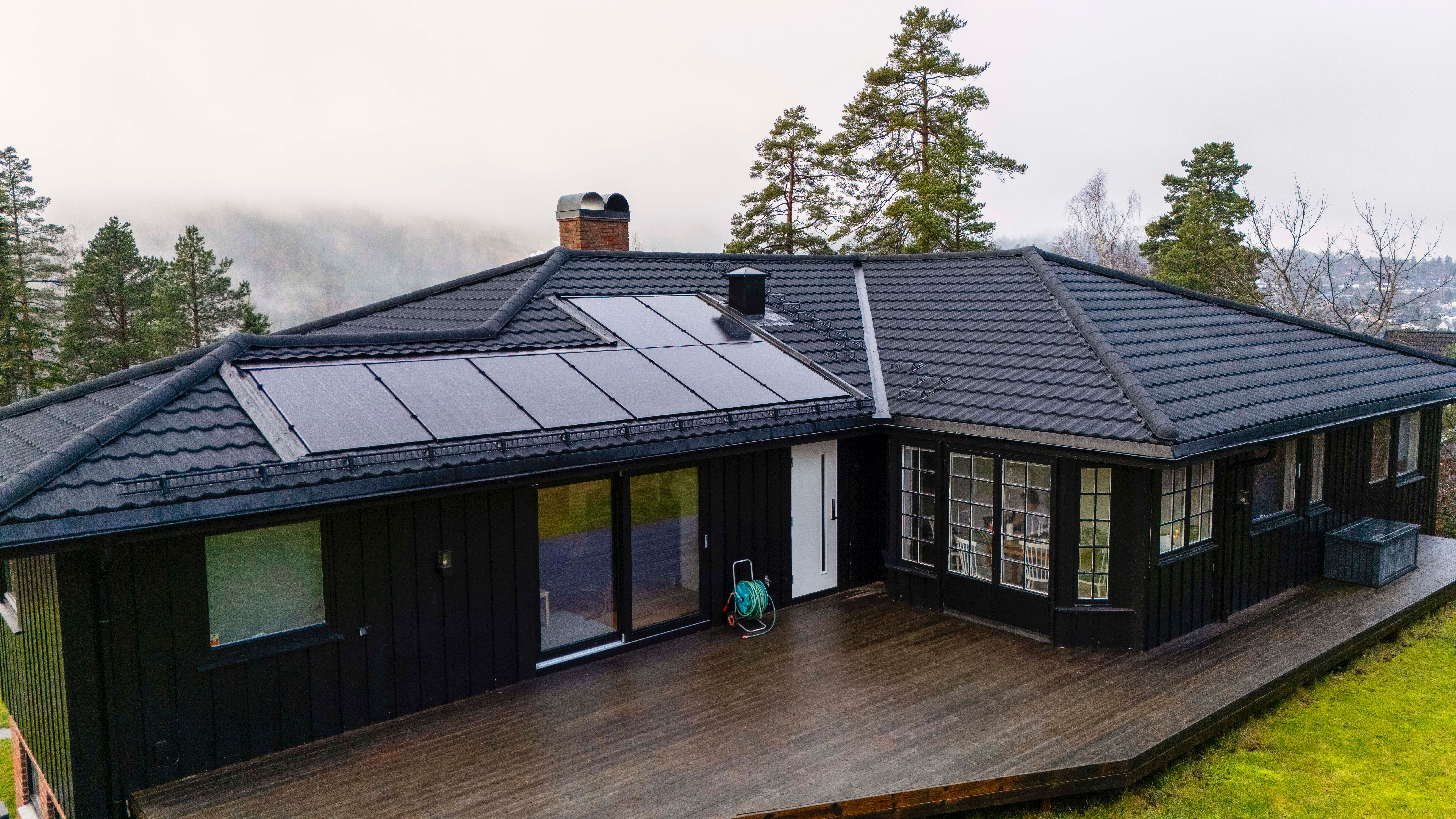 Svart hus med ny svart takstein og integrerte solceller 