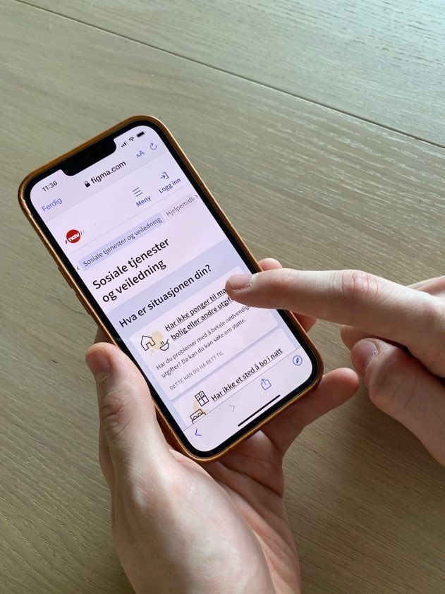 Person som peker på mobilutgaven av nav.no