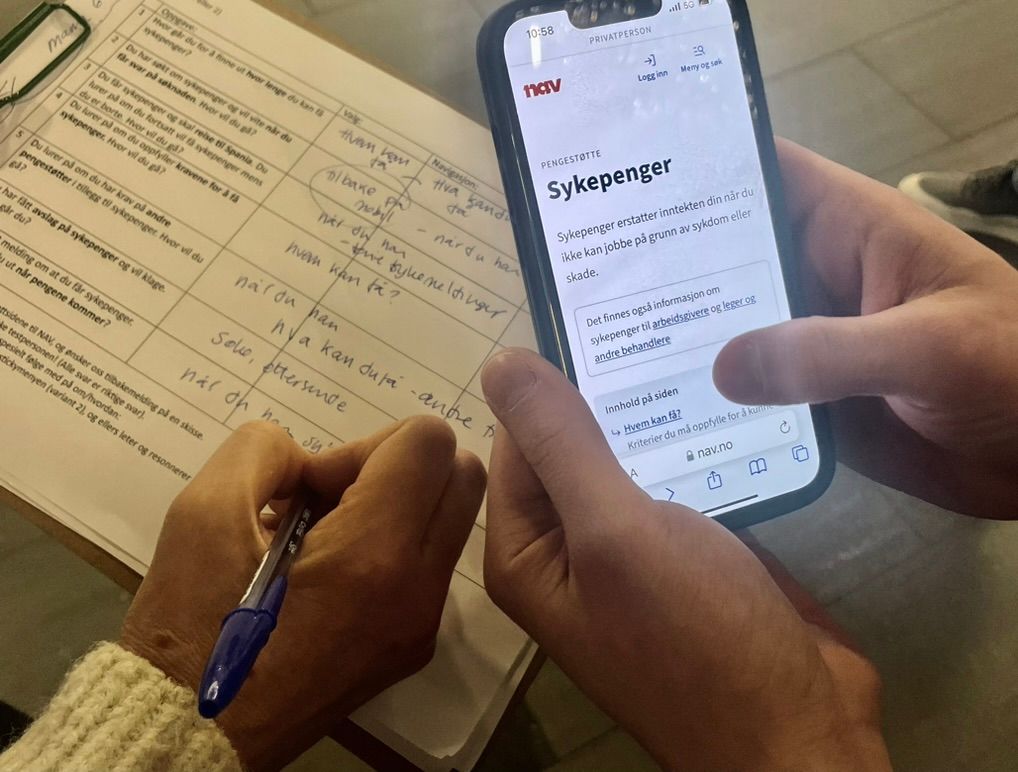 En testperson tester produktsiden for sykepenger på mobil mens en moderator noterer funn på et ark