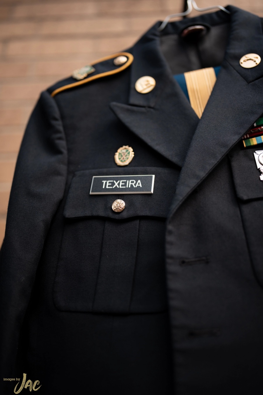A navy military dress uniform hanging on a door