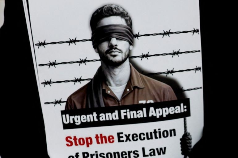 A man holds a sign as Palestinians take part in a protest against the the Israeli death penalty law in Ramallah in the Israeli-occupied West Bank on March 31, 2026 