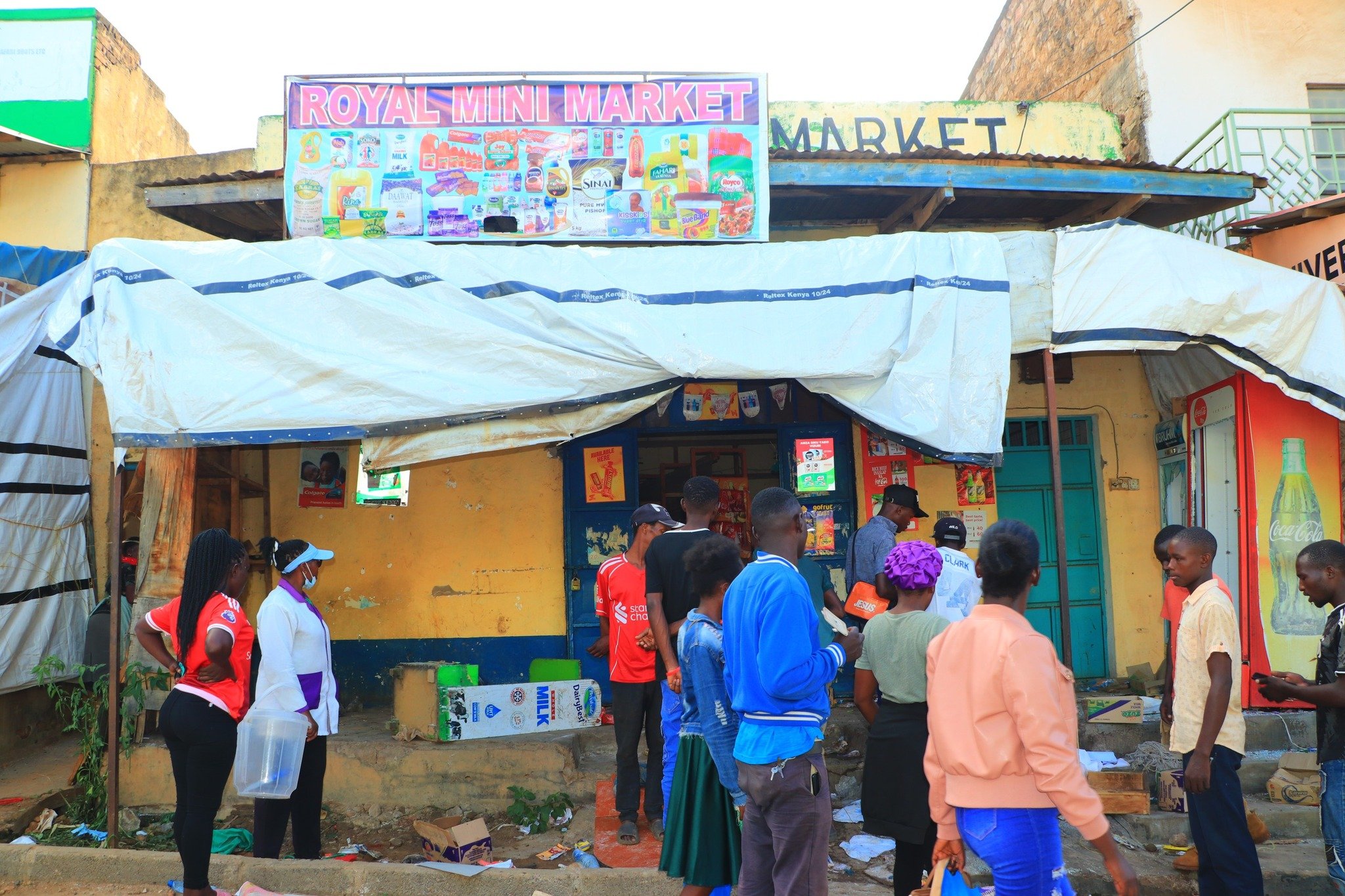 People gather outside a Somali-owned shop in Mwingi town which was looted on Wednesday April 29