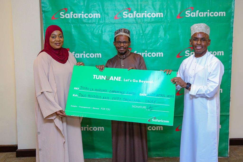 Citizen TV's Mwanahamisi Hamadi (left) and Juma Namlola former chairman of the Kenya Muslim Media Practitioners Association recieve a Sh200,000 dummy cheque from Safaricom CEO Peter Ndegwa during an Iftar programme