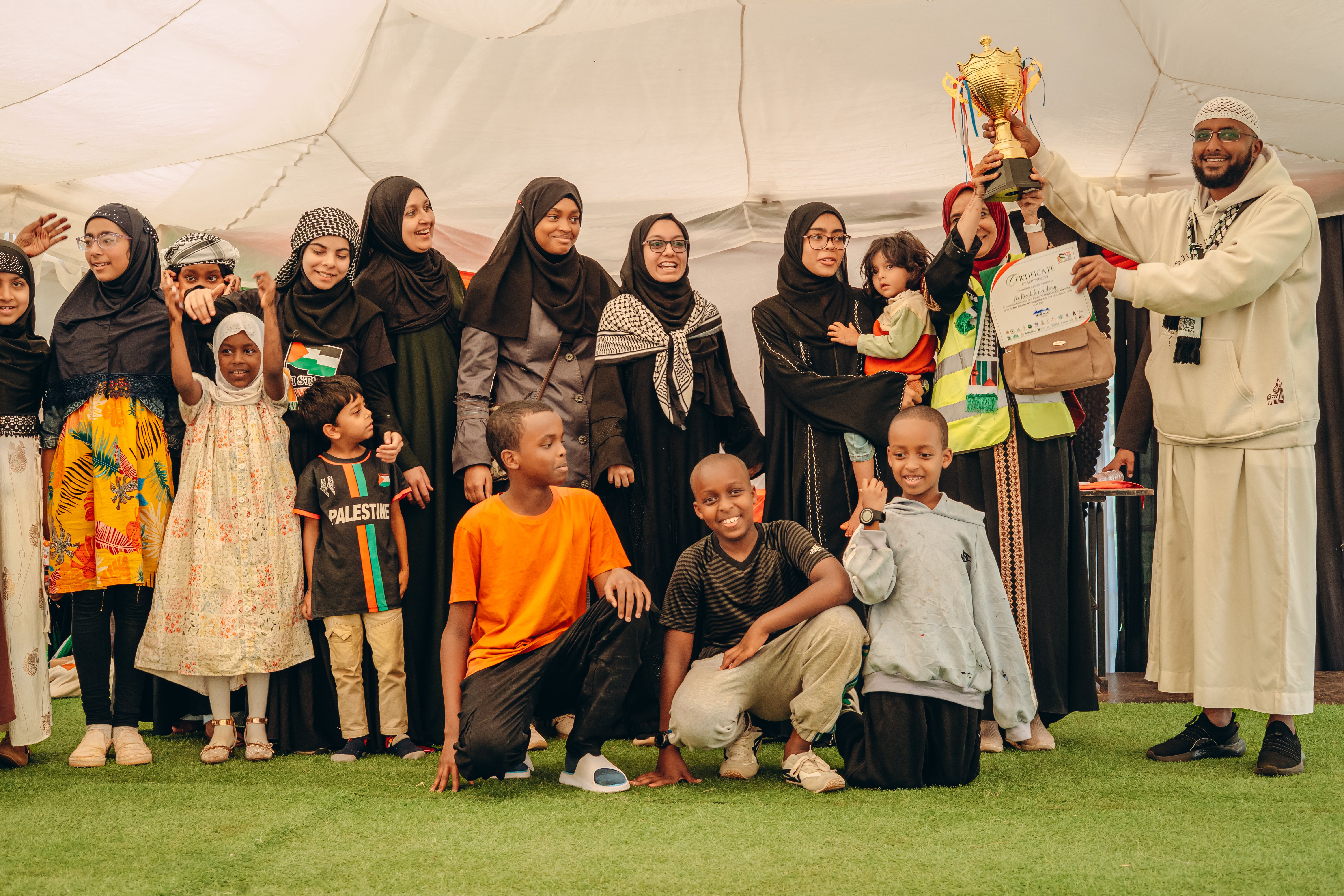The VFP chairman Ahmed Sharrif presents a trophy to teachers, parents and pupils of Al Risalah Academy, who emerged as the top fundraisers in the campaign.