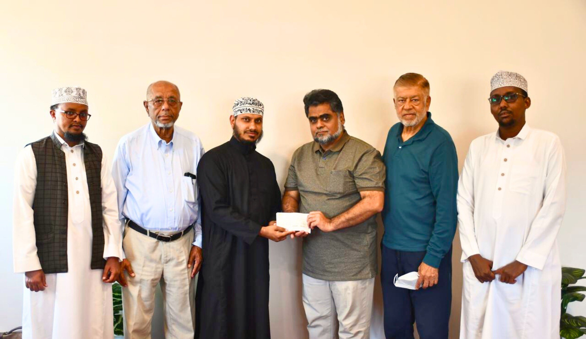 Imam Abdulrahman Ishaq presenting a cheque to the Jamia Mosque Finance officer Abubakar Nazir . From left isthe Jamia Mosque Da'wah Director Sheikh Muhammad Sheikh, Parklands Mosque official Suleiman Harunani, the chairman Fauz Qureshi and Ahmed Affey, the head of human resource at Jamia Mosque