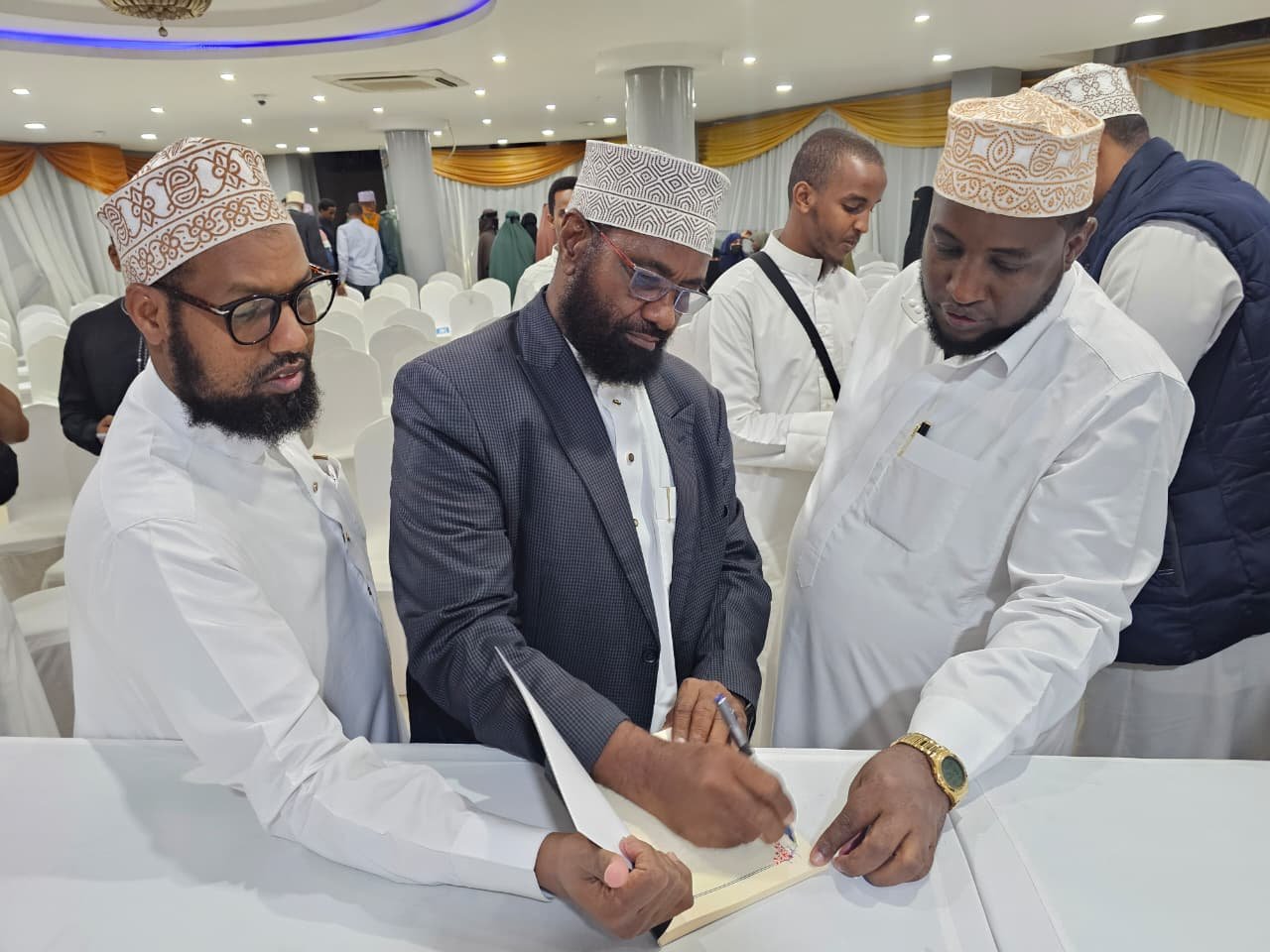 The author Sheikh Hussein Burale signs autographs for the people who bought the book