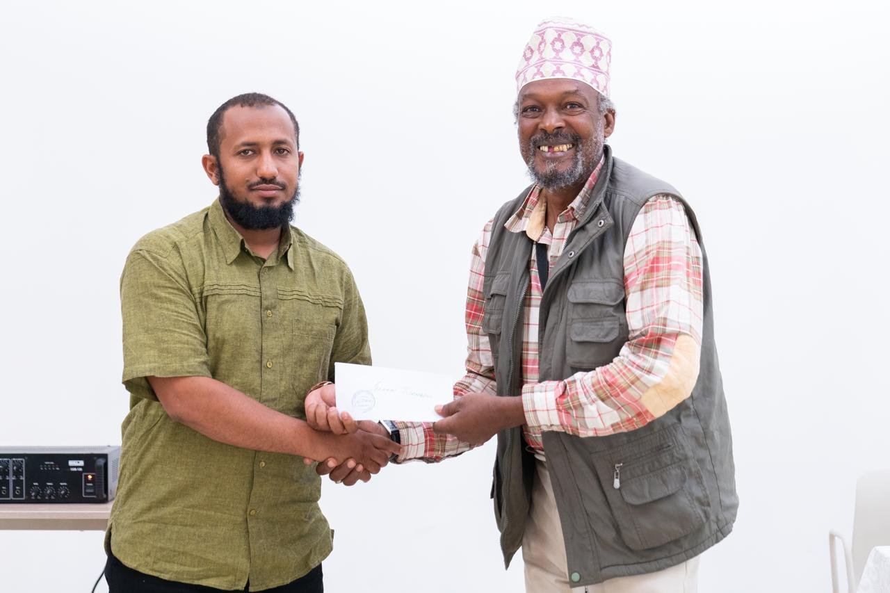 Masjid Al Ameen Administrator Salim Famau hands over a cheque to Ibrahim Wambugu, a beneficiary of the empowerment support