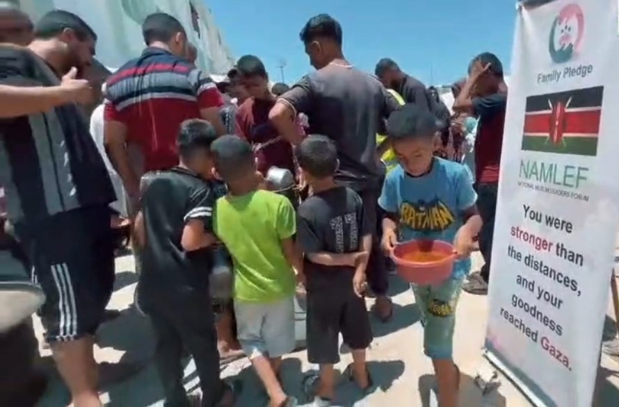 A boy walks with a bowl of food at a NAMLEF Sponsored feeding centre in Gaza 