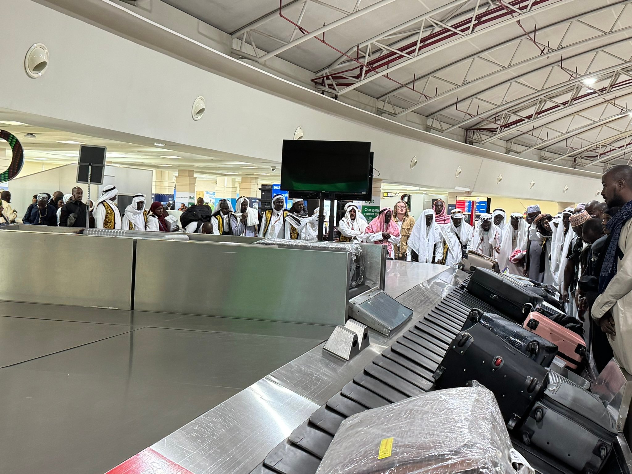 Returning pilgrims wait for the baggage at the Jomo Kenyatta International Airport