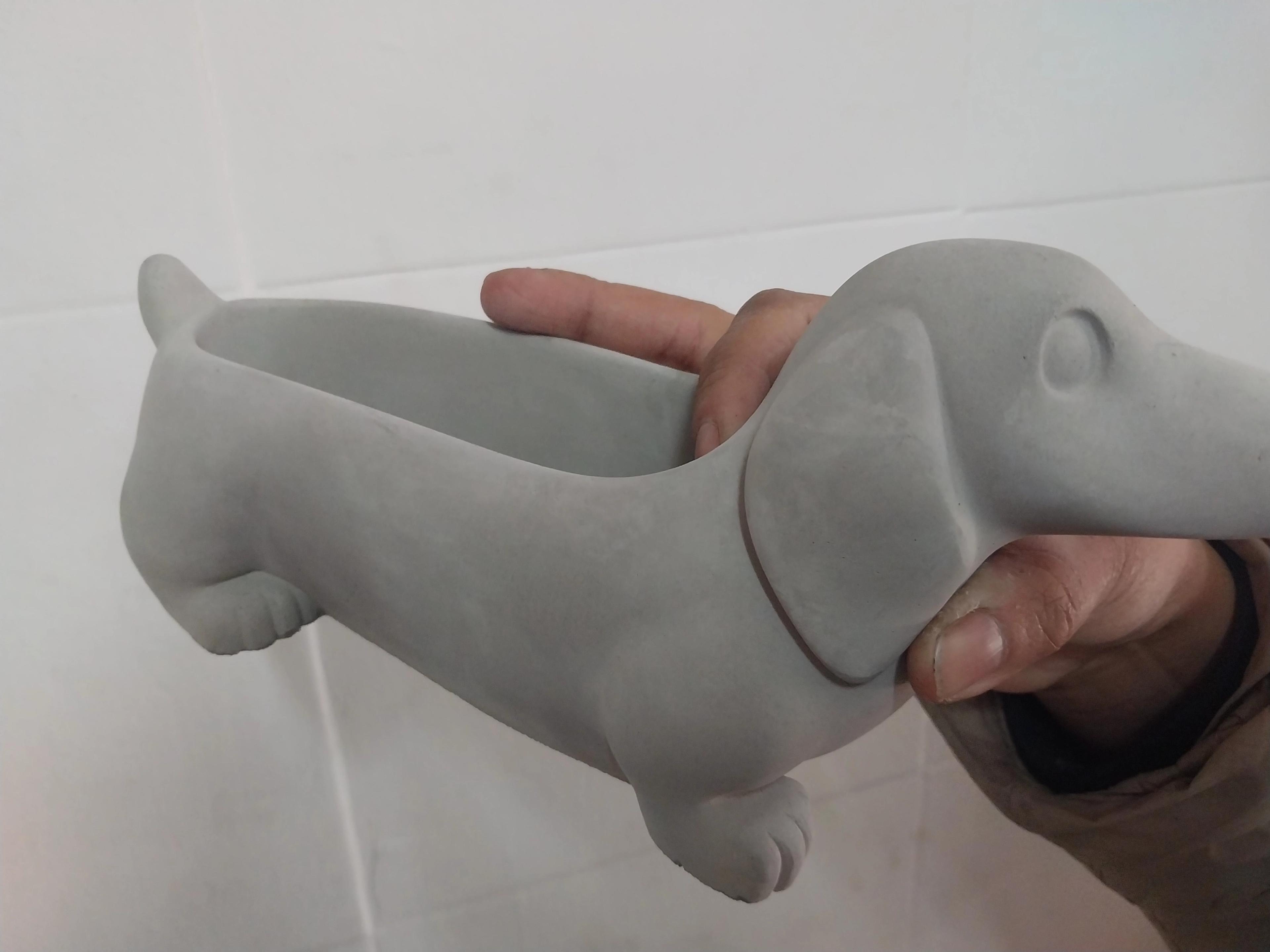 Maceta de perro salchicha de cemento en crudo
