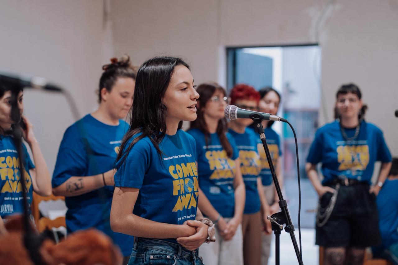 Alumna de Coro Broadway cantando con acompañada de los músicos del a banda y sus compañeras