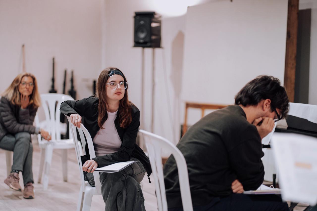 Alumnos escuchando al profesor mientras ensayan una escena