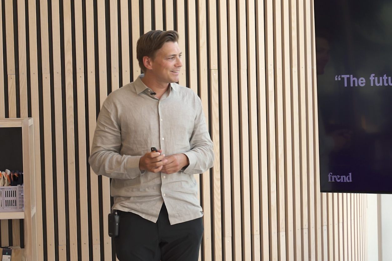 Mann holder presentasjon foran trepanelvegg og skjerm som viser "The future of frend".
