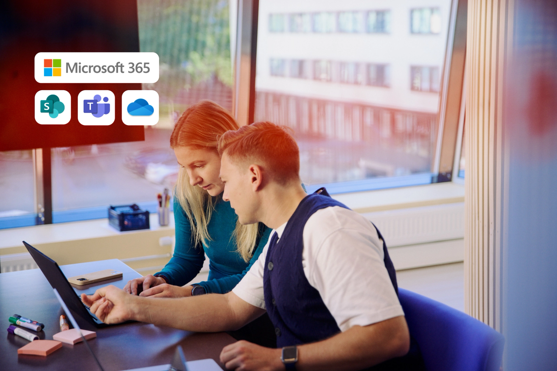 To kolleger jobber sammen på en bærbar PC med Microsoft 365, SharePoint, Teams og OneDrive-ikoner synlige.