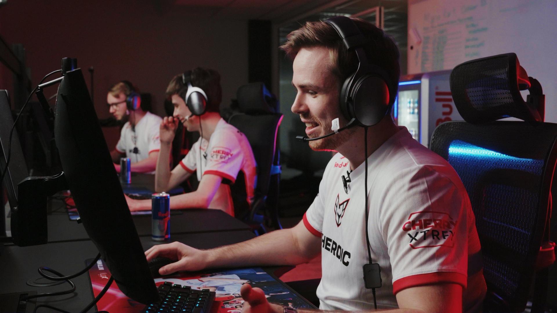 E-sportspillere fra Heroic sitter foran datamaskiner med headset og konsentrerer seg.